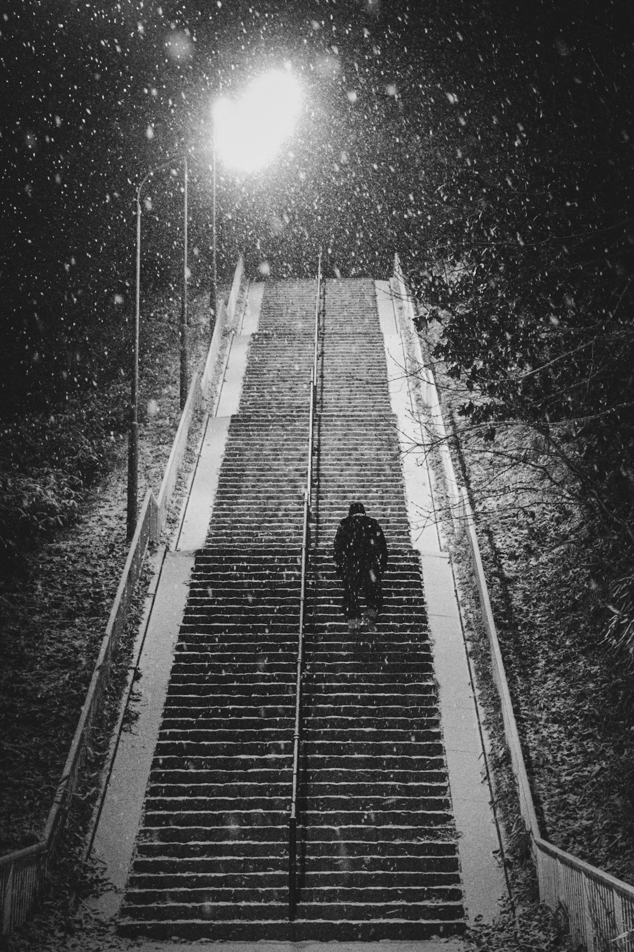 雪の降る夜の長い階段を歩く人影