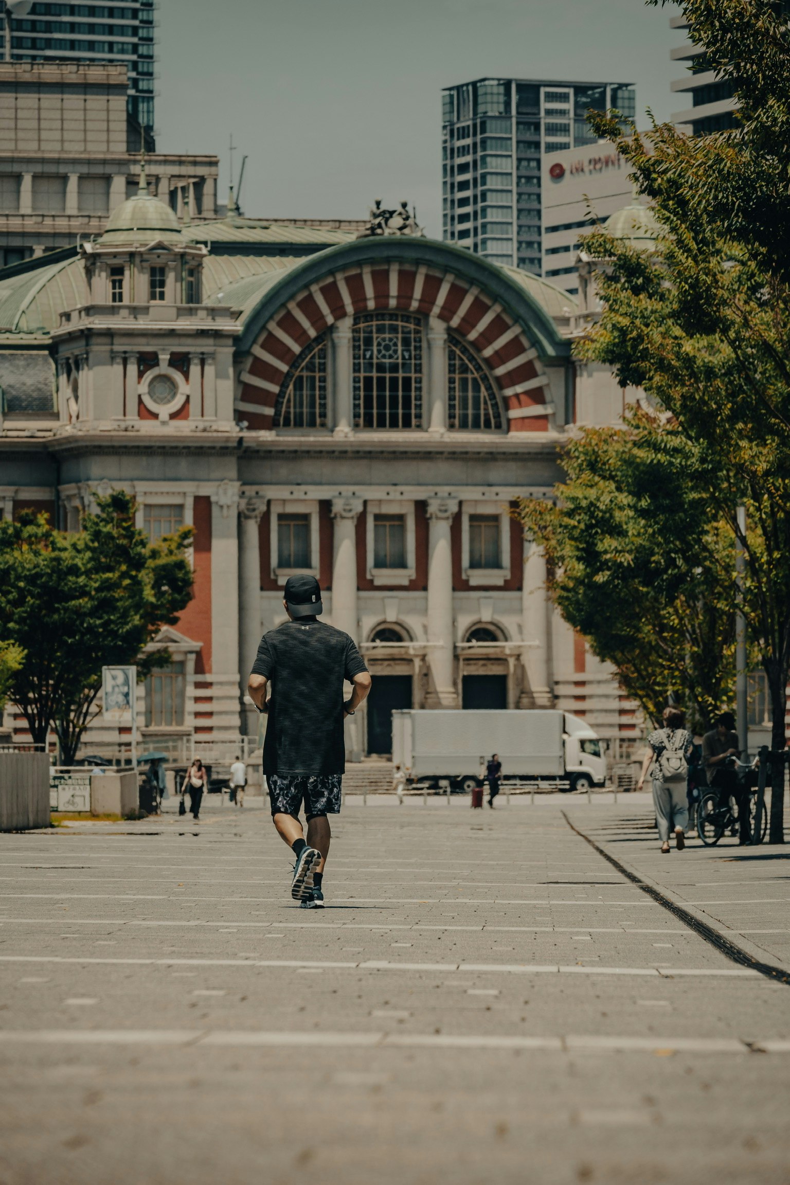 一个人在历史建筑前慢跑，周围是绿色的树木