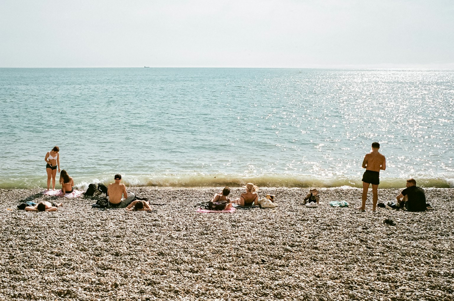 一群人在海灘上放鬆，海面平靜