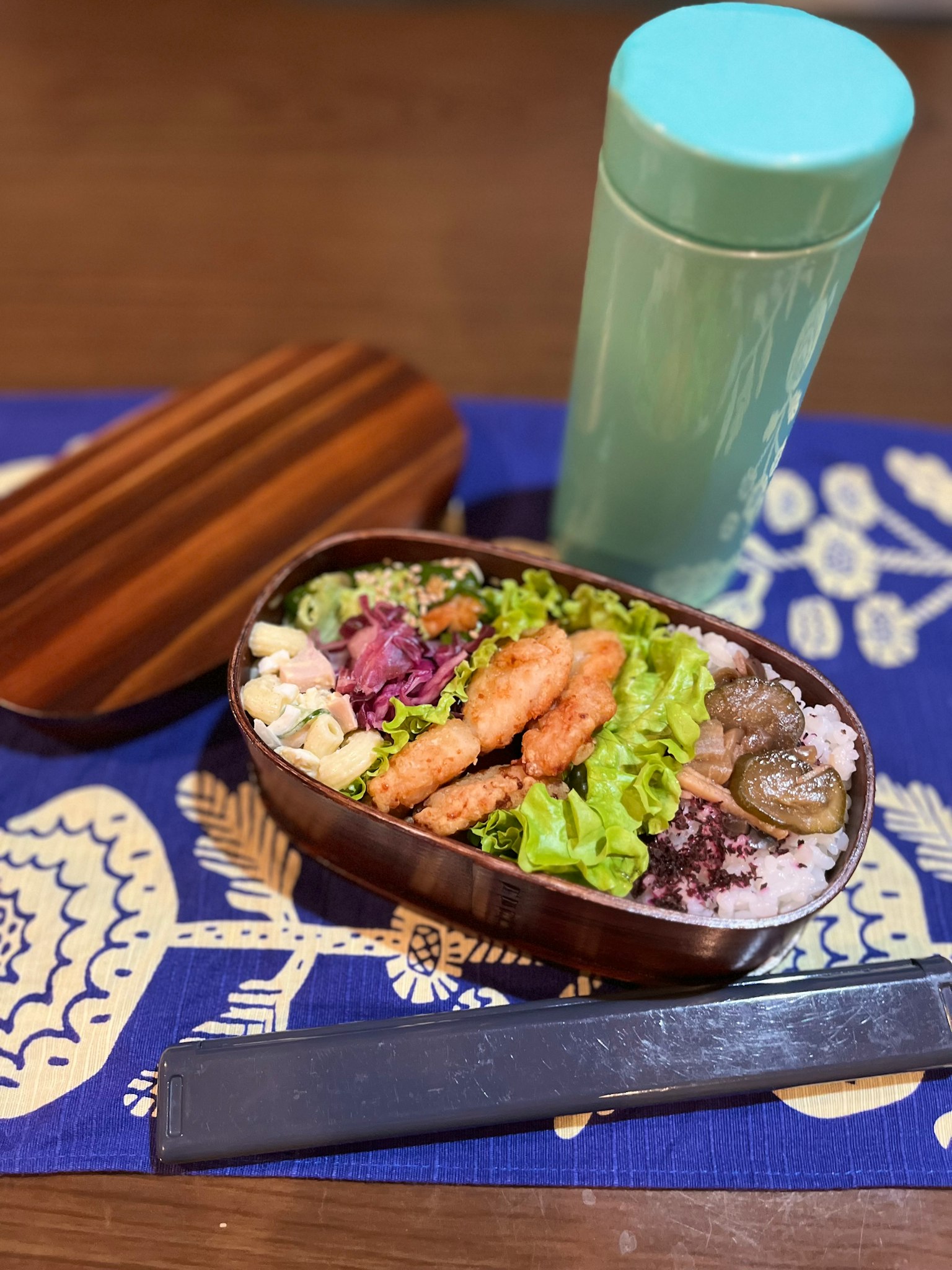 木製便當盒裡裝滿了色彩豐富的沙拉和米飯