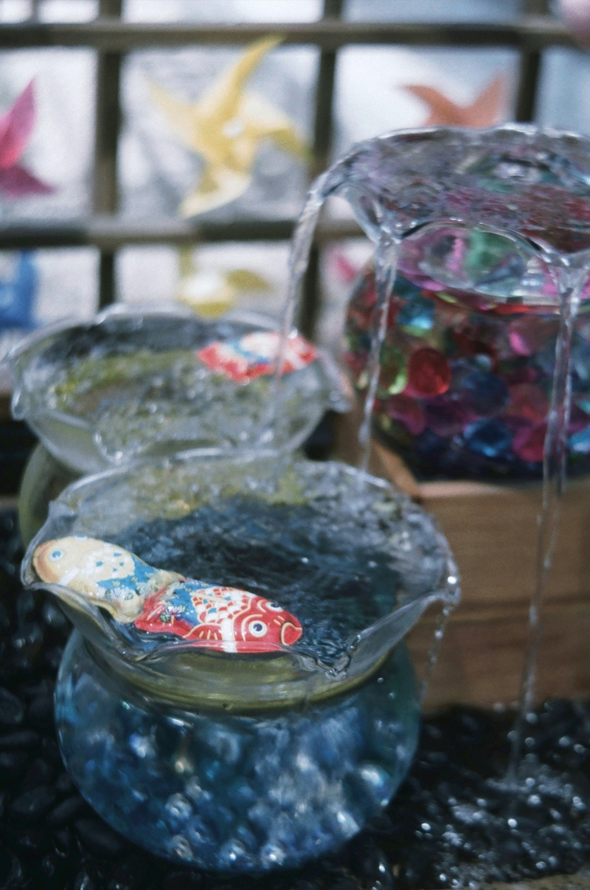 花手水の金魚鉢と花びらのある水面