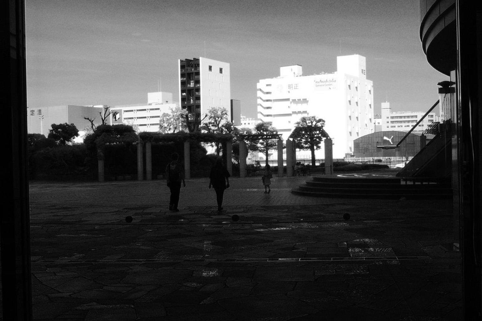 Escena urbana en blanco y negro con personas caminando
