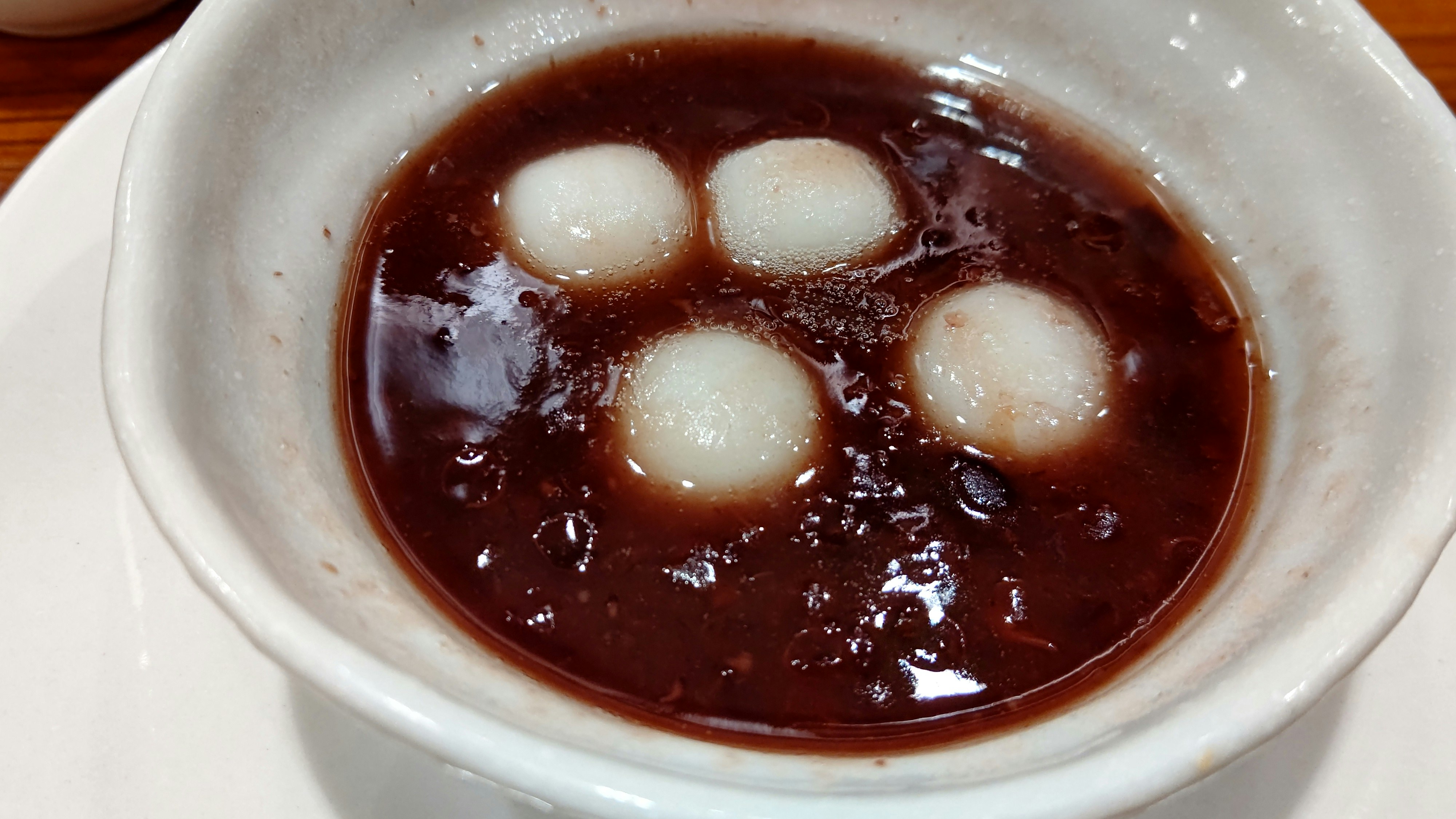 mangkuk sup gelap dengan pangsit/dumpling putih