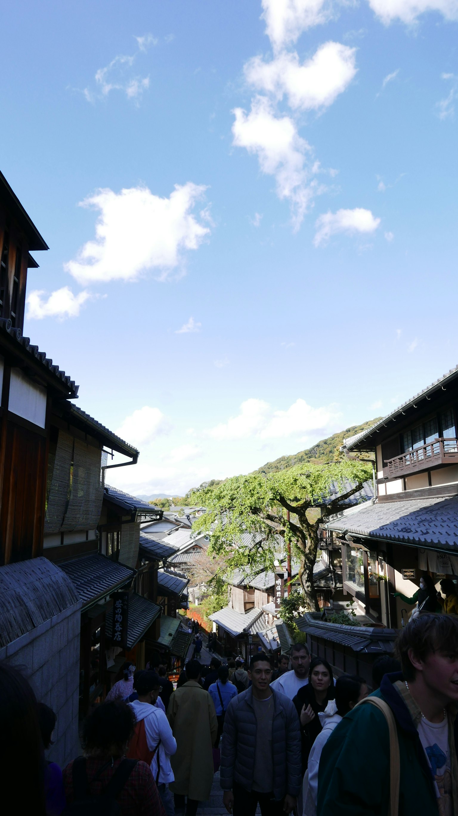 人们在传统街道上走，背景是木建筑和蓝天