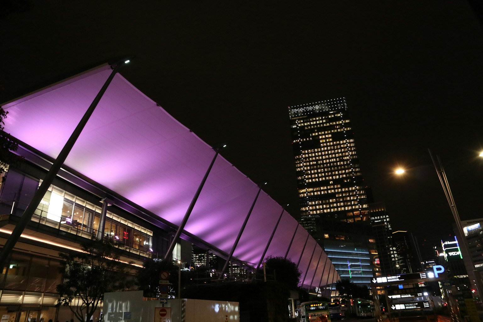 Night cityscape featuring a purple canopy and illuminated skyscrapers