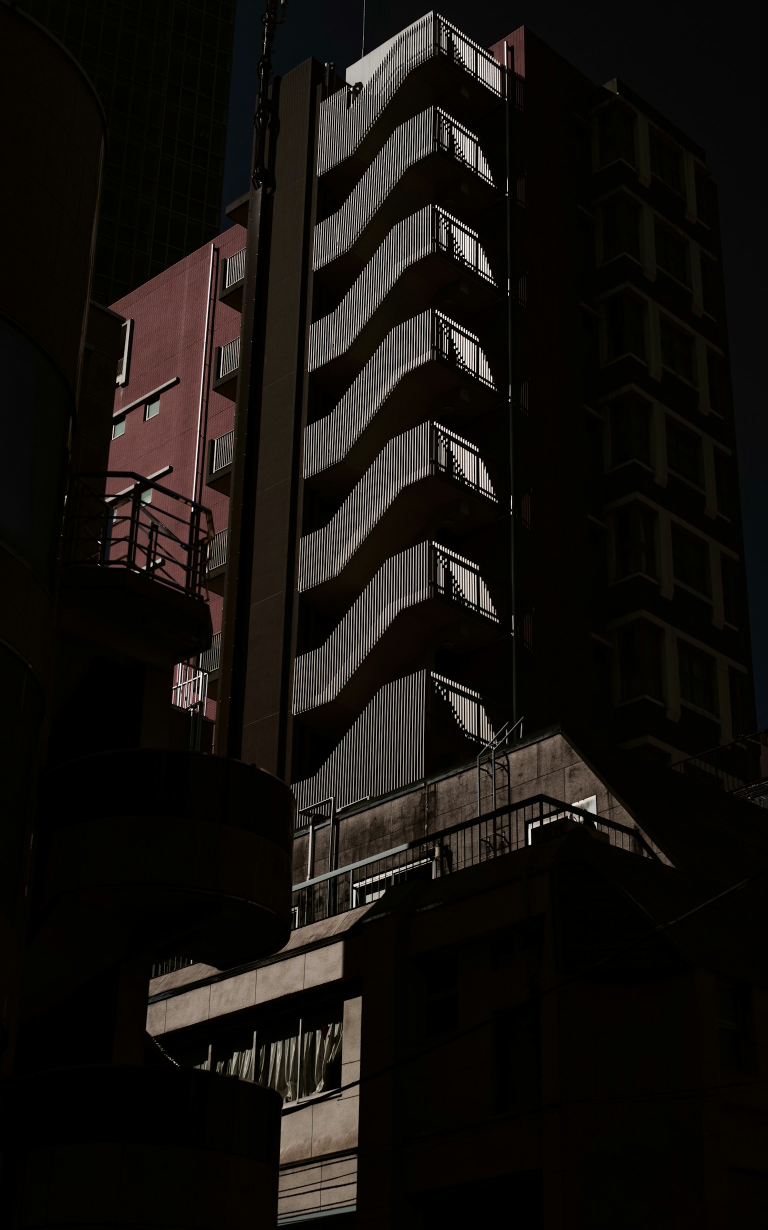 Immeuble de grande hauteur avec balcons ondulés sur fond sombre