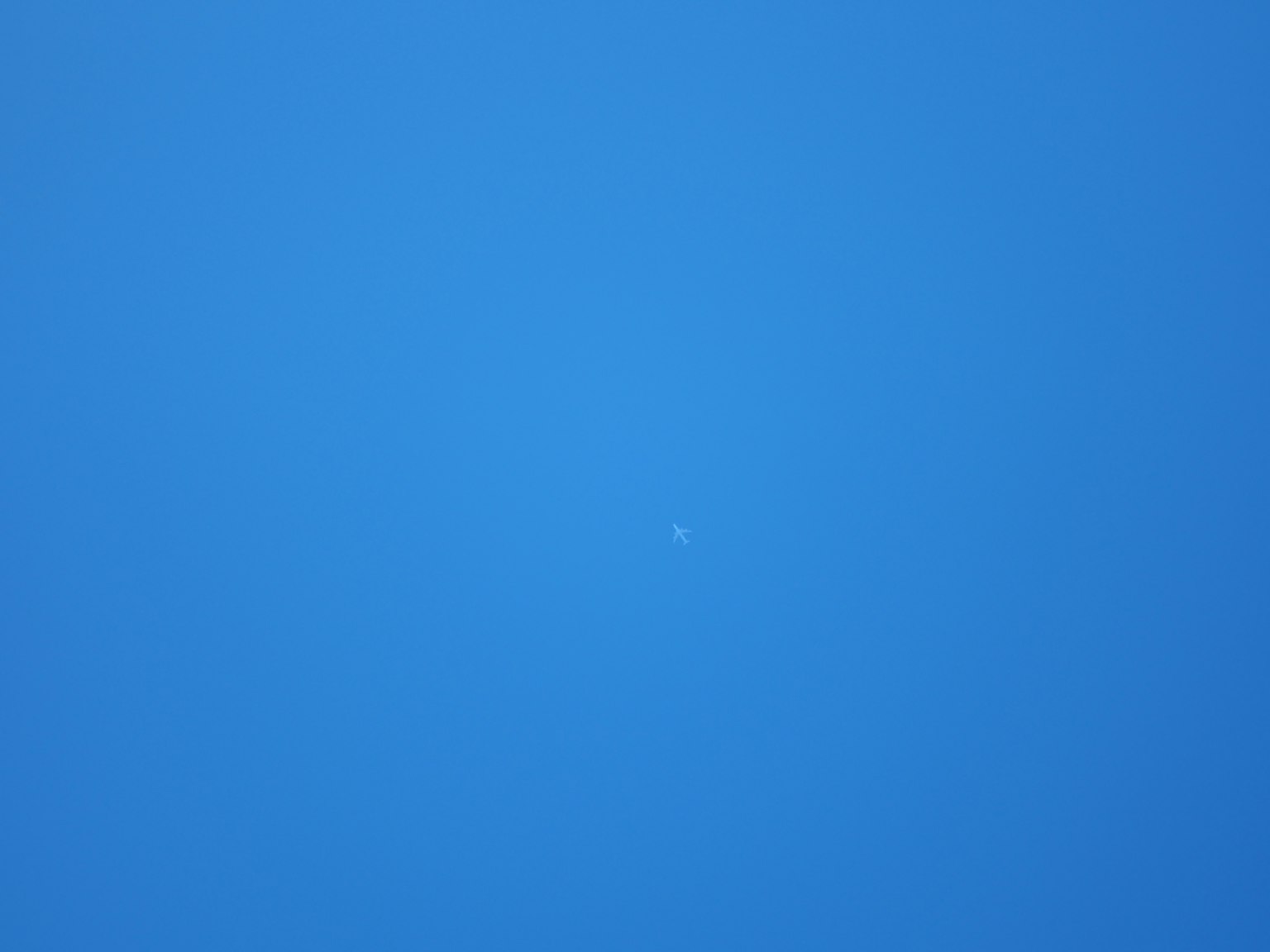 Un piccolo punto bianco contro un cielo blu chiaro