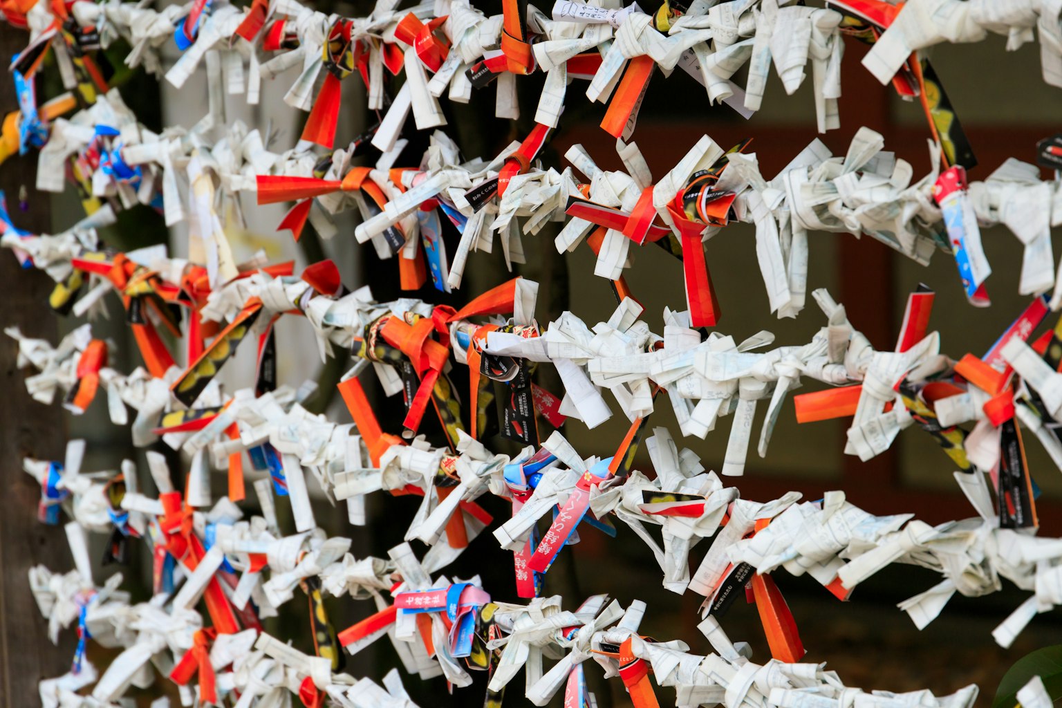 Colorful small paper strips tied together in a traditional Japanese wishing wall