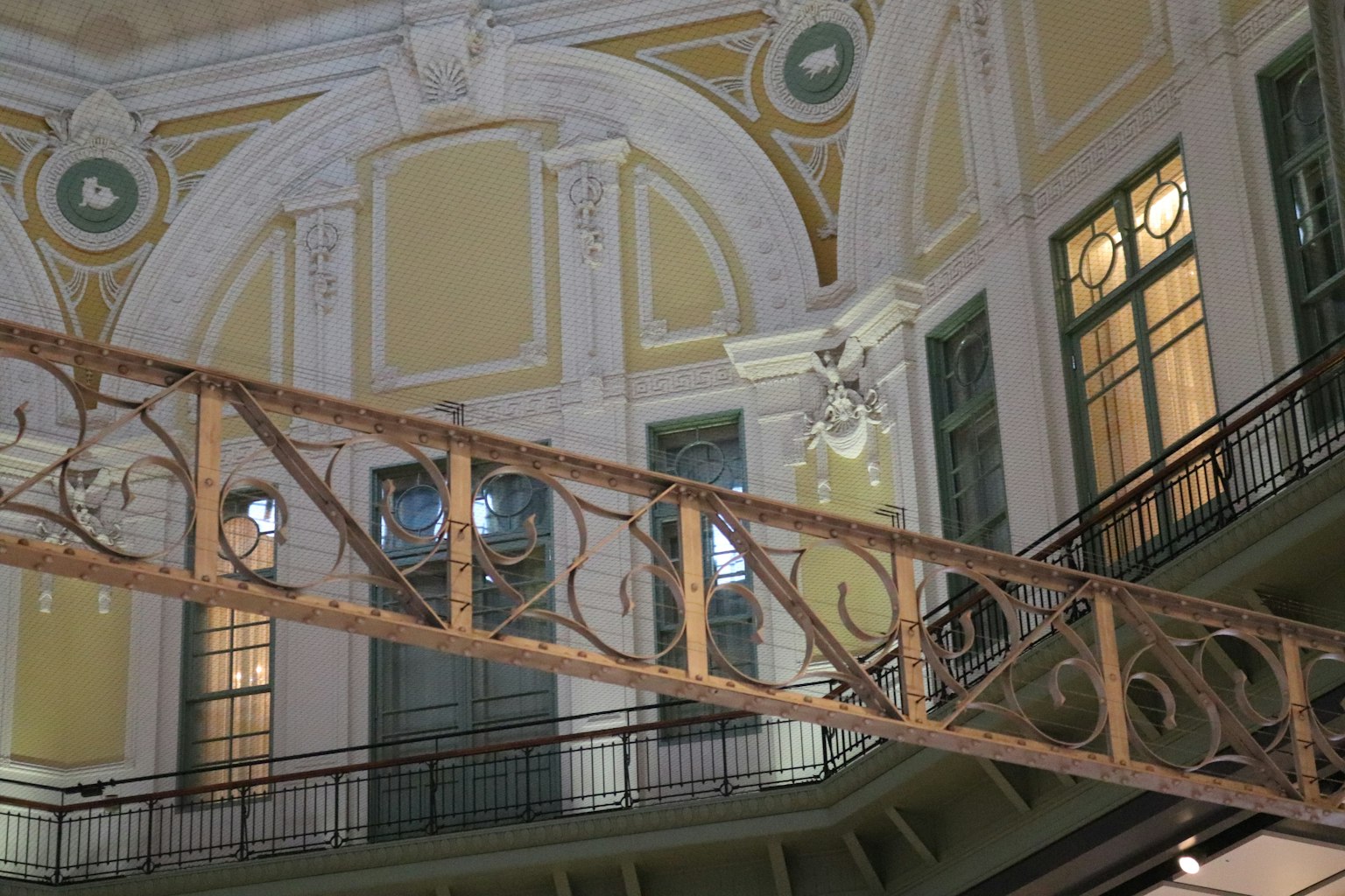 Innenraum eines historischen Gebäudes mit schönen Dekorationen und einer Holzgeländer Treppe sowie Fenstern