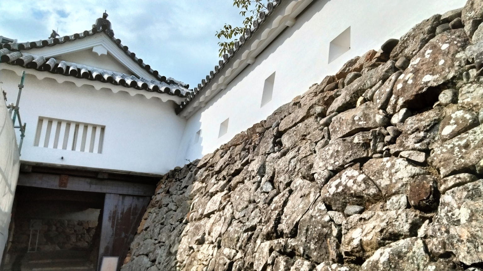 传统日本建筑的一部分，带有石墙和白色外墙