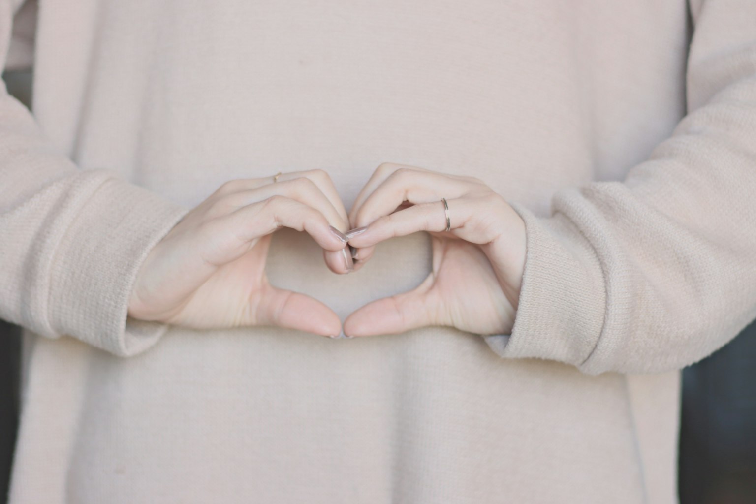 Persona che forma una forma a cuore con le mani