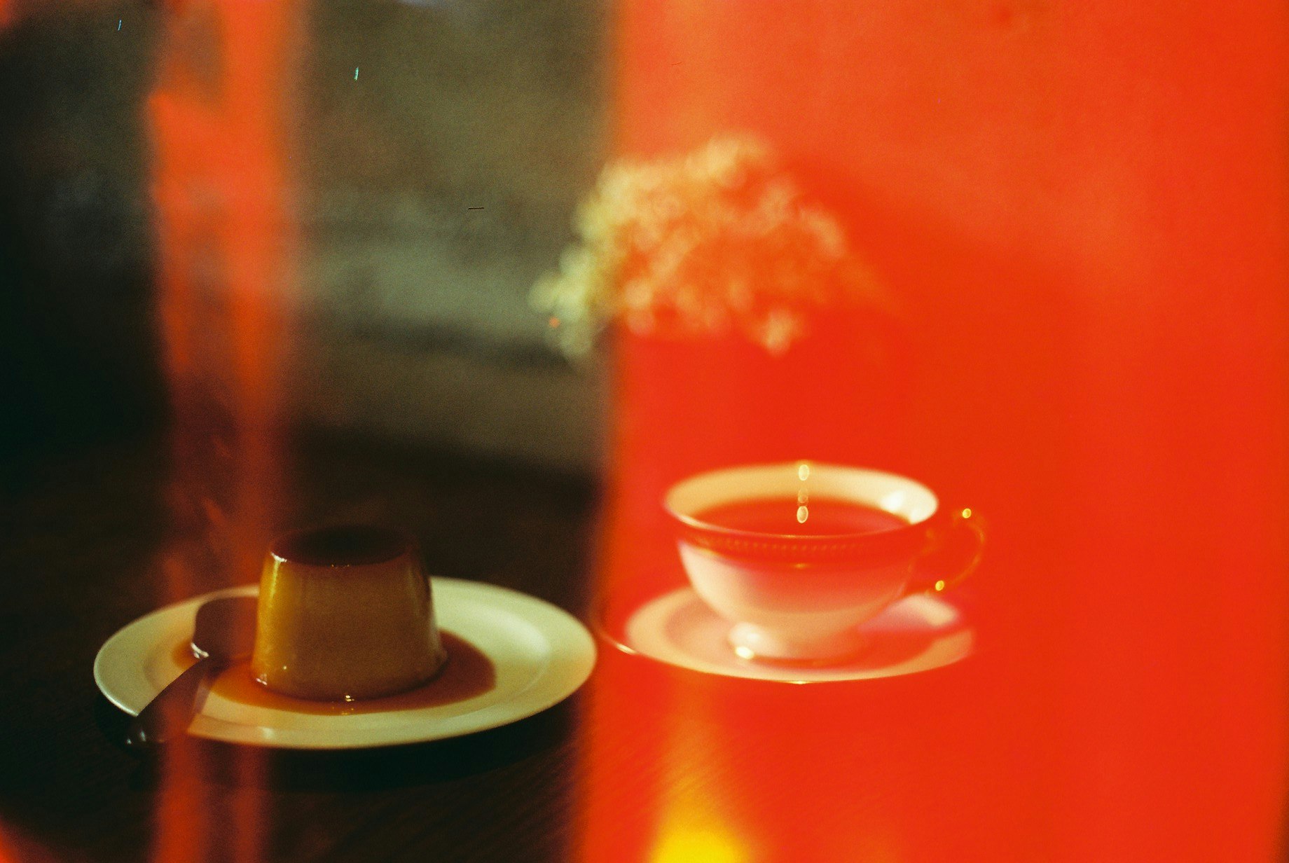 Tazas de café sobre una mesa con fondo rojo y vapor