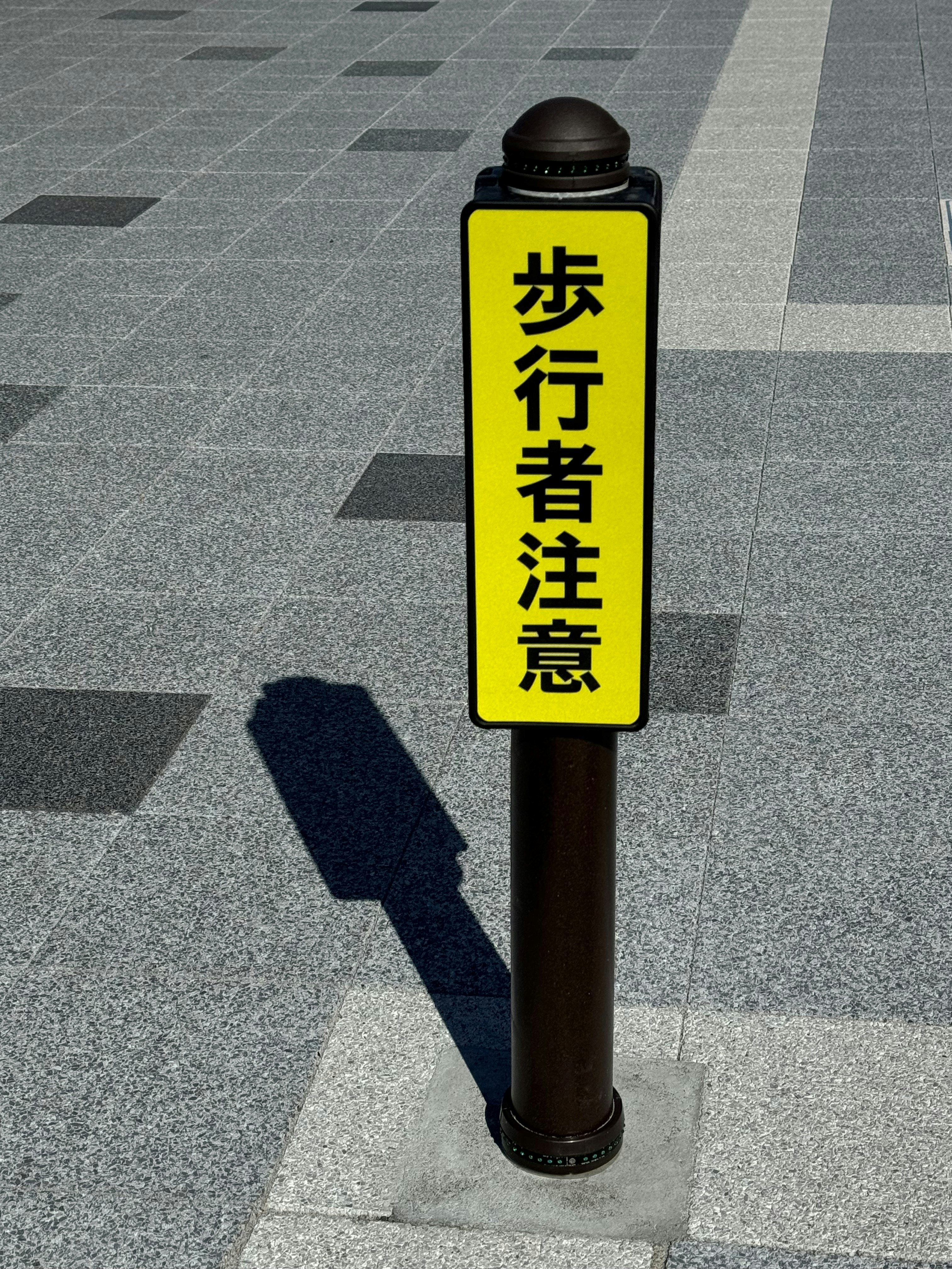 横断歩道の歩行者注意の標識が立つ歩道