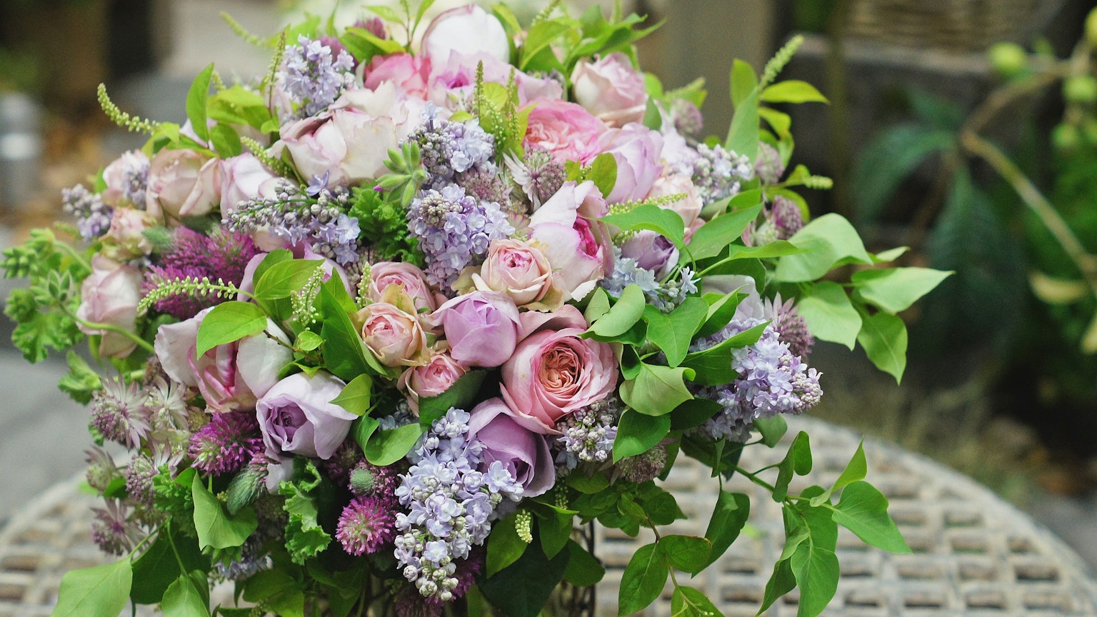 Un bouquet coloré avec des roses roses et violettes ainsi que des lilas
