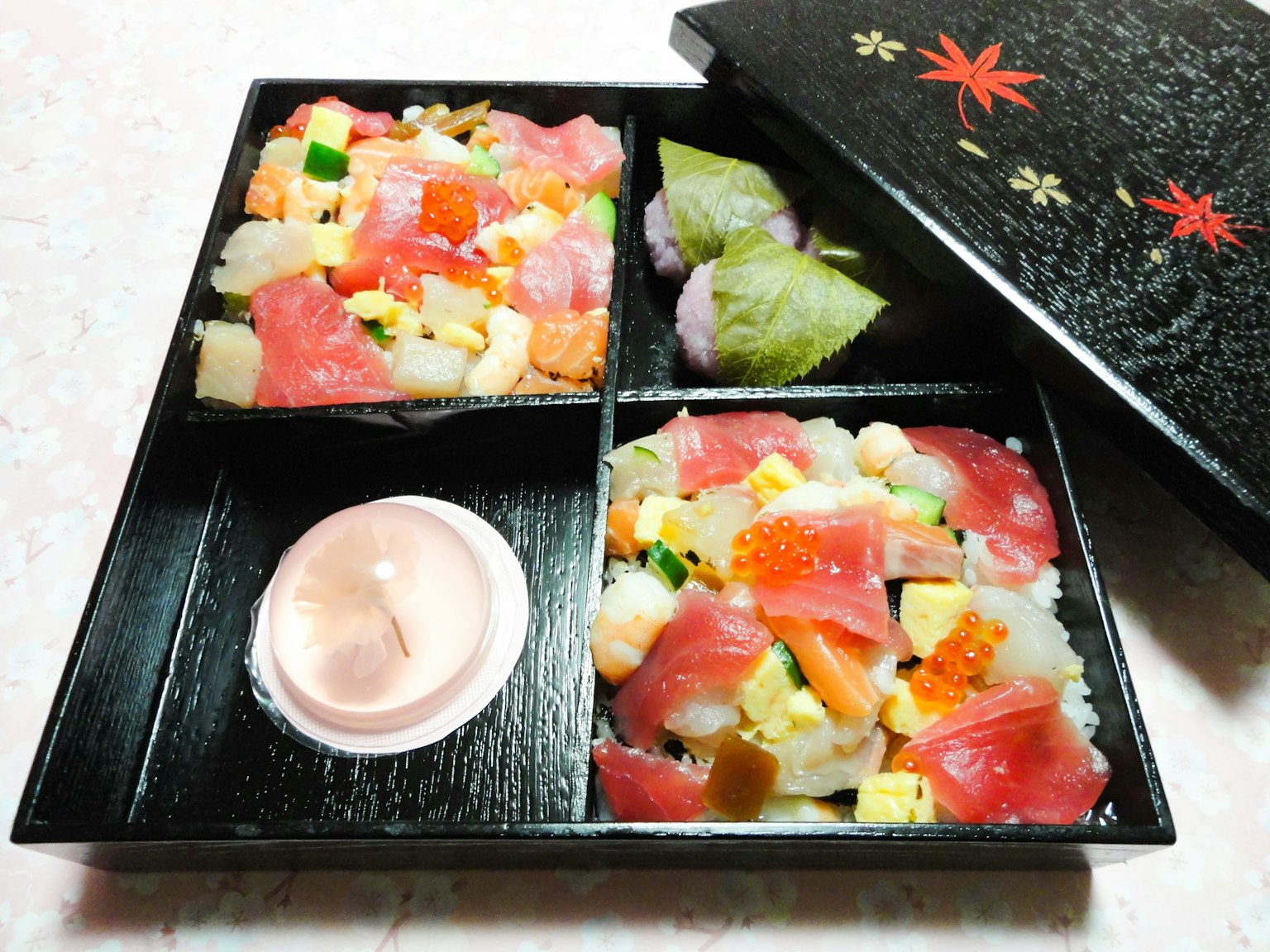 Sushi y sashimi dispuestos en una caja bento negra