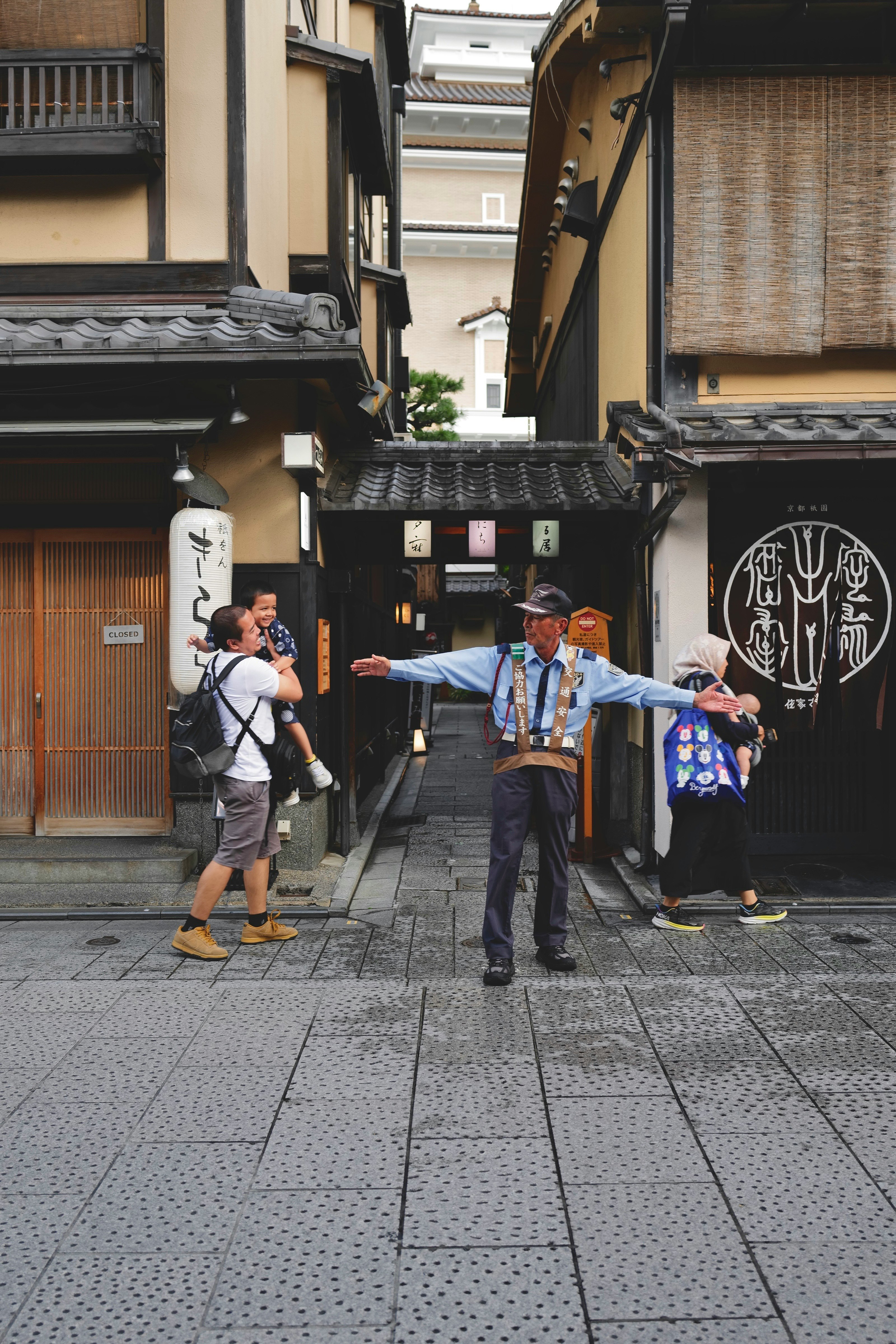京都の路地で着物姿の人がポーズをとる街並み