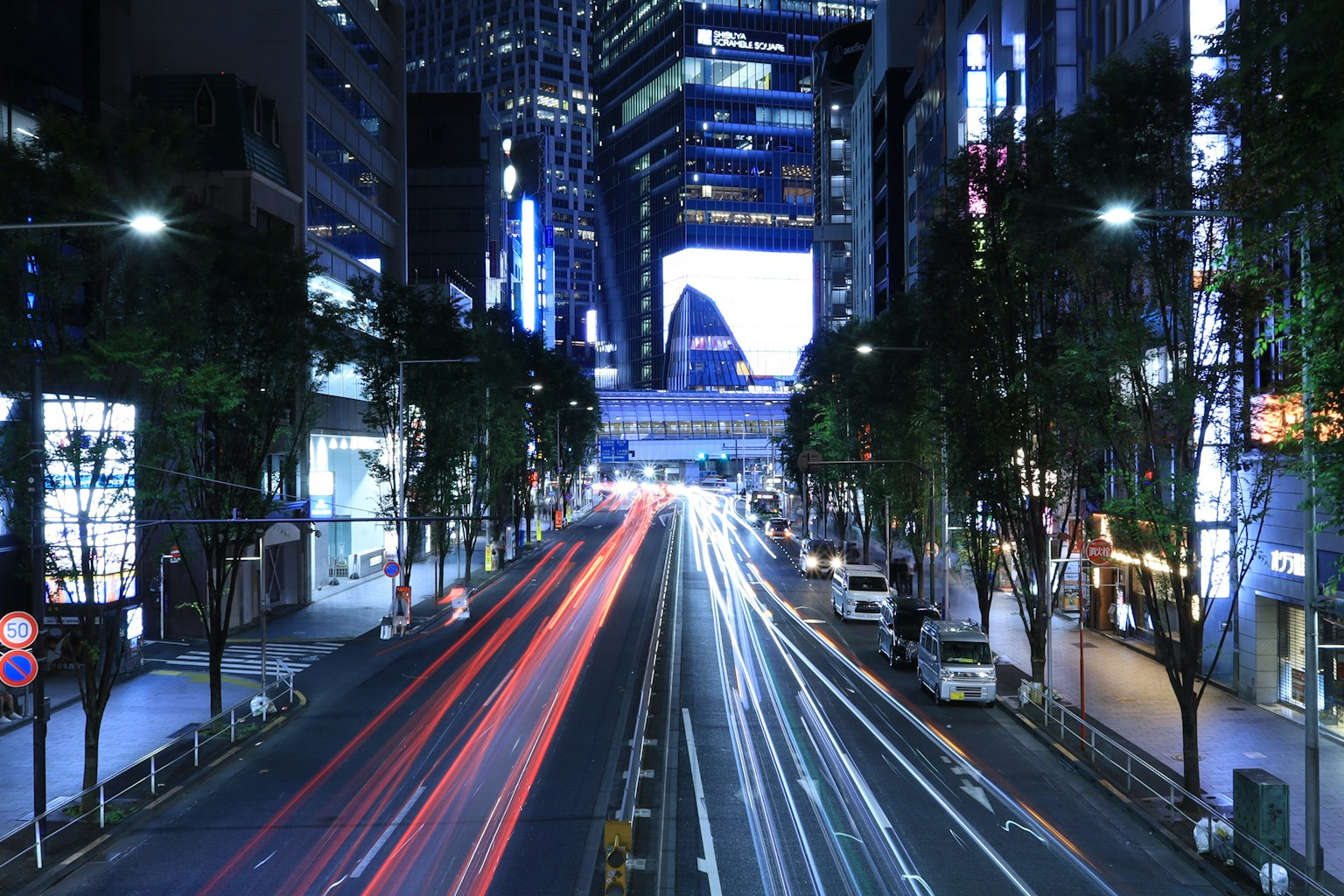 夜の都市風景 高層ビルと車のライトが流れる