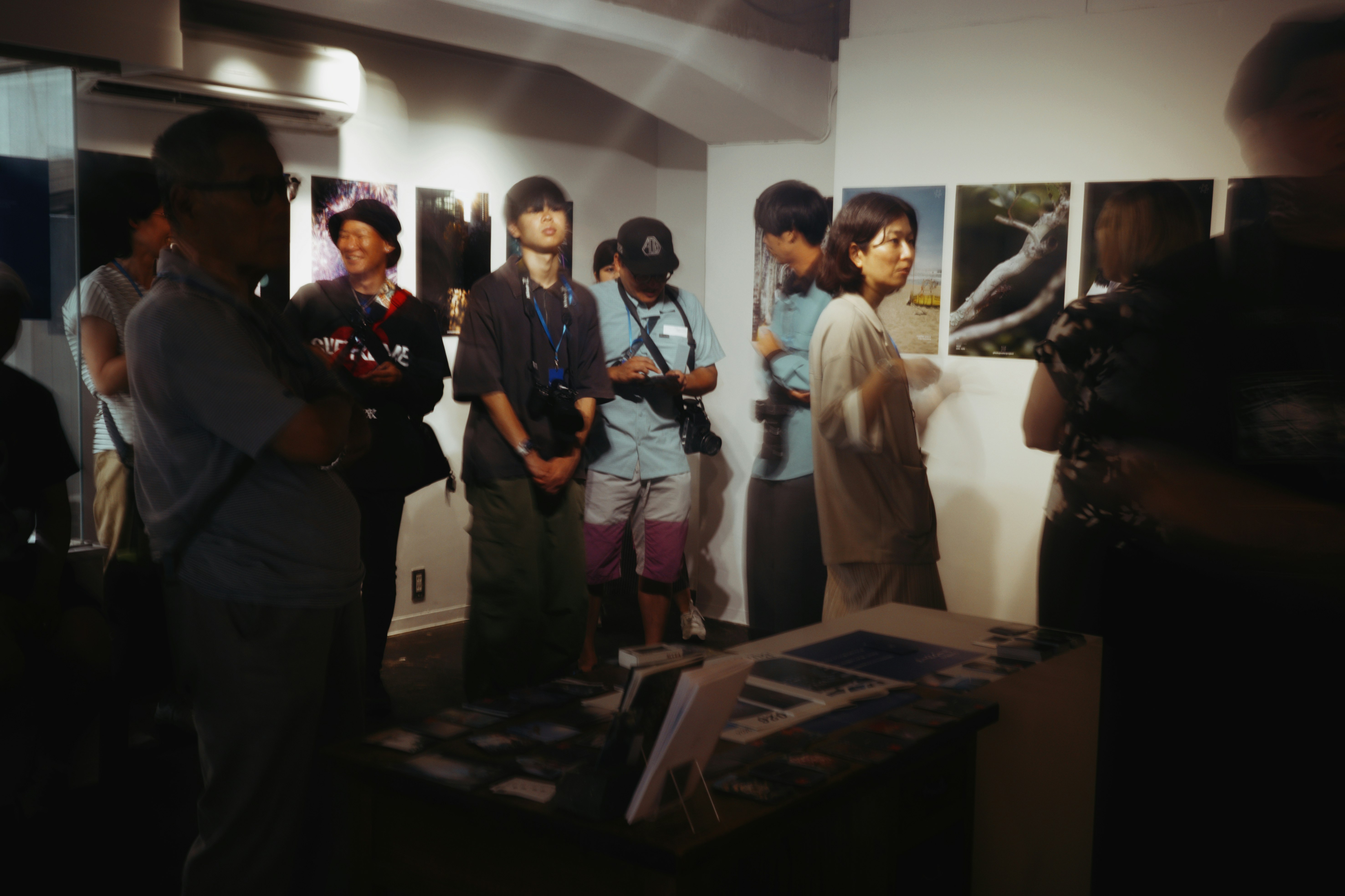 京都のギャラリーで展示を見つめる来場者たちの室内風景