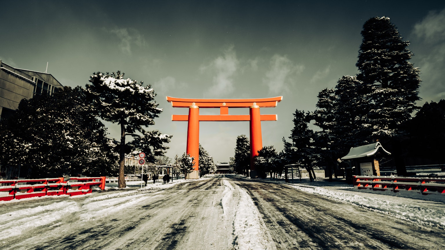Jalan yang tertutup salju dengan gerbang torii merah