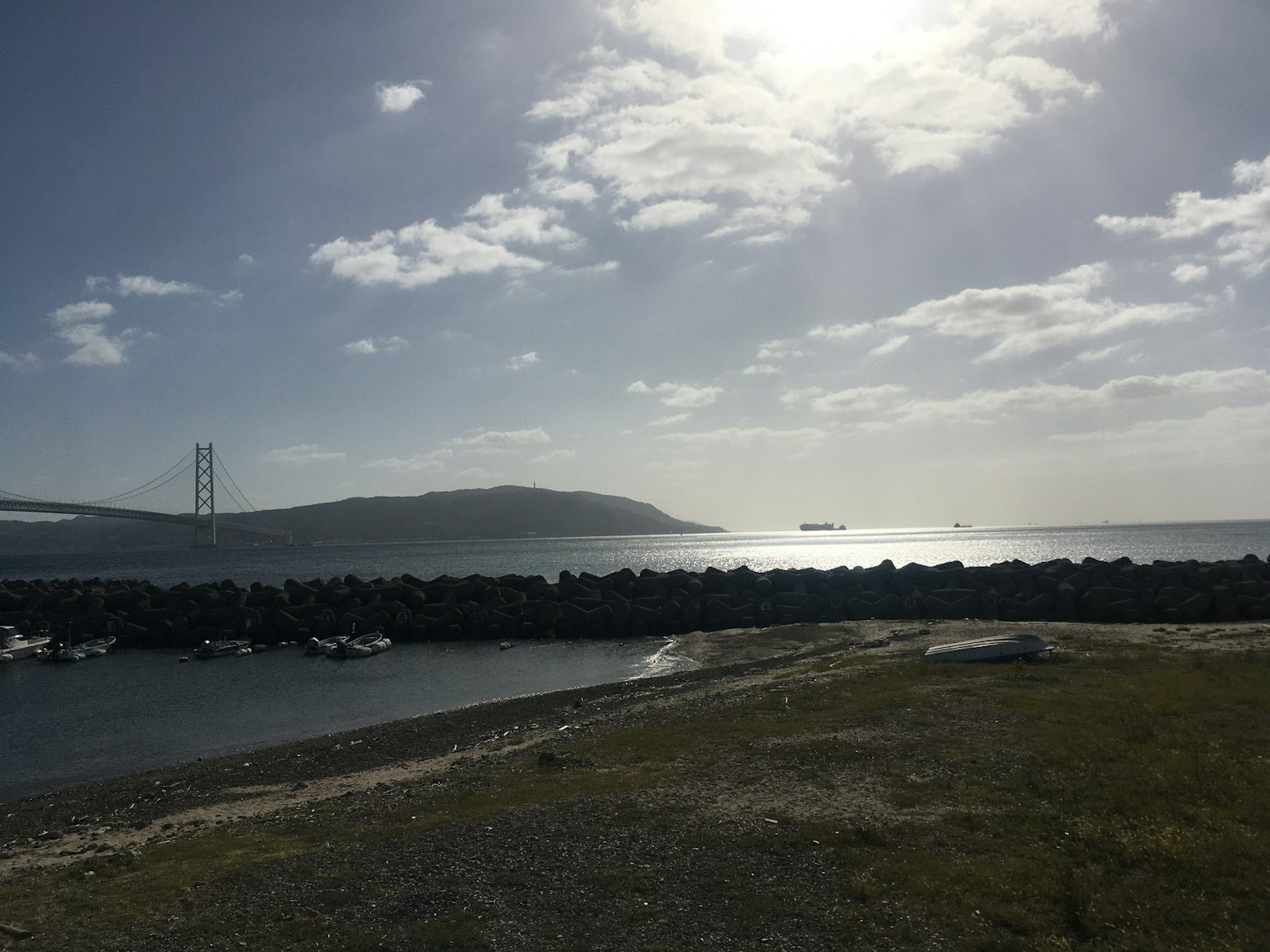 Paesaggio di mare e cielo calmo con nave e ponte in lontananza