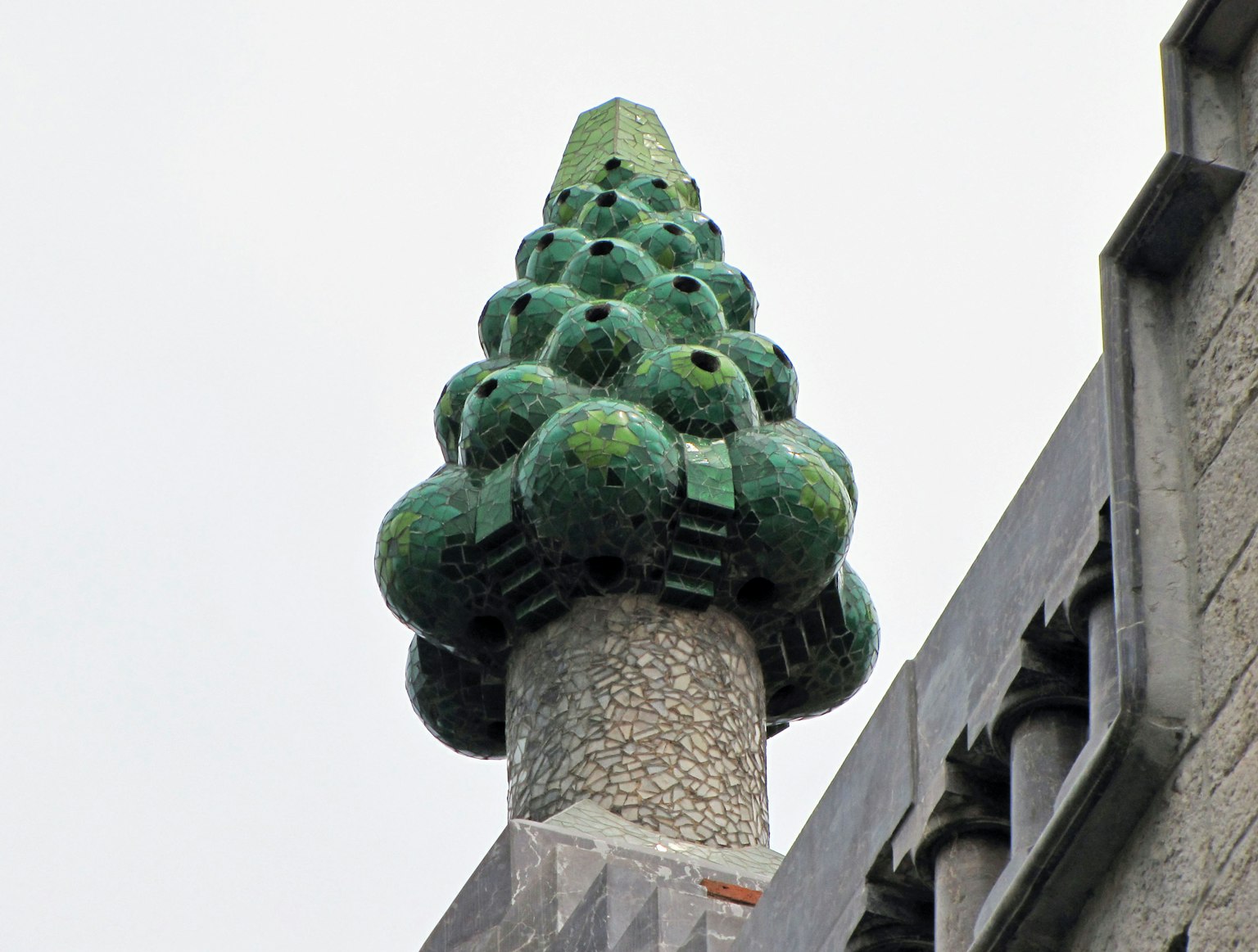 Scultura decorativa verde che somiglia a un cono di pino in cima a una torre