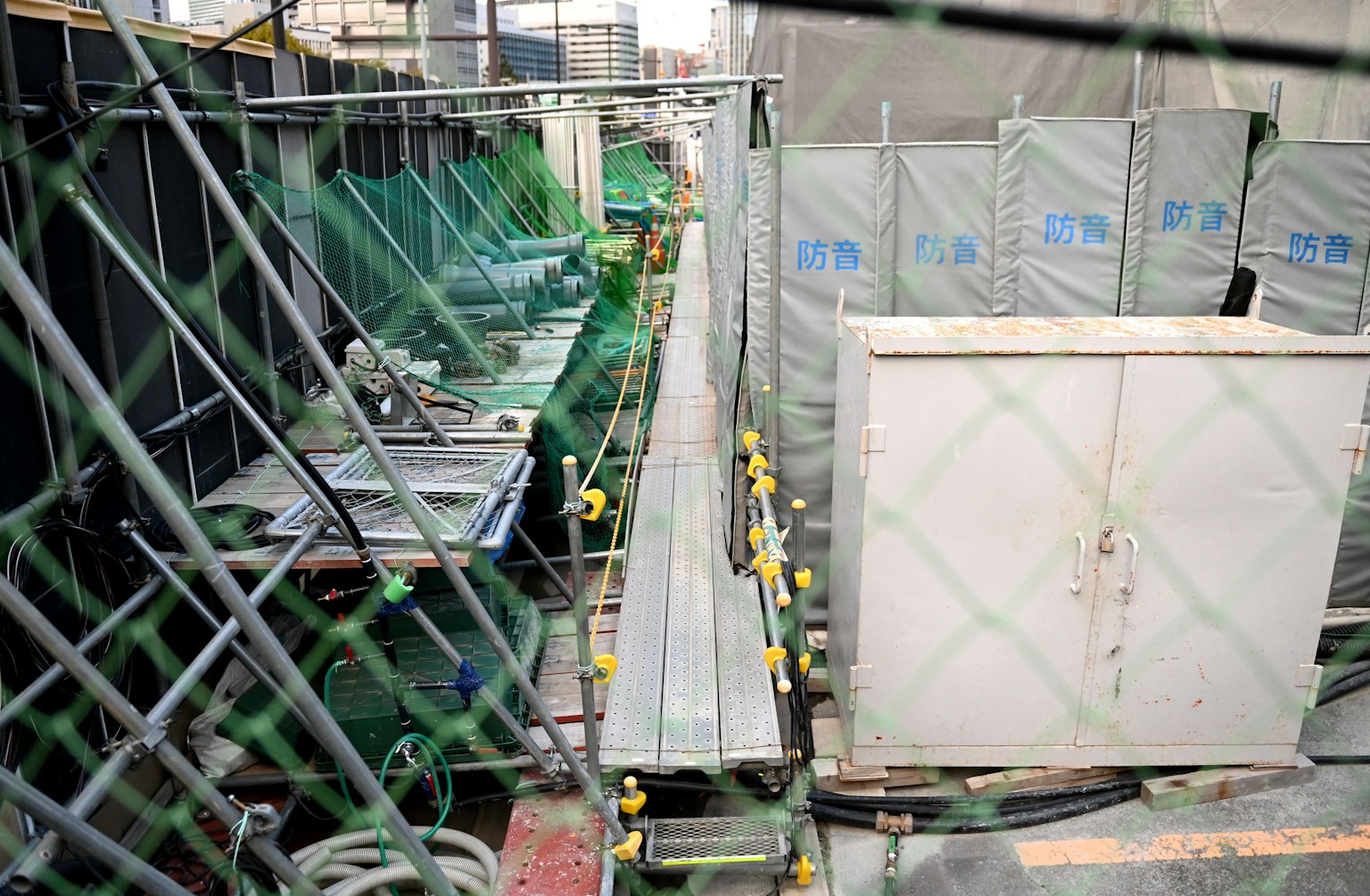 Chantier de construction avec des équipements verts et un chemin en métal