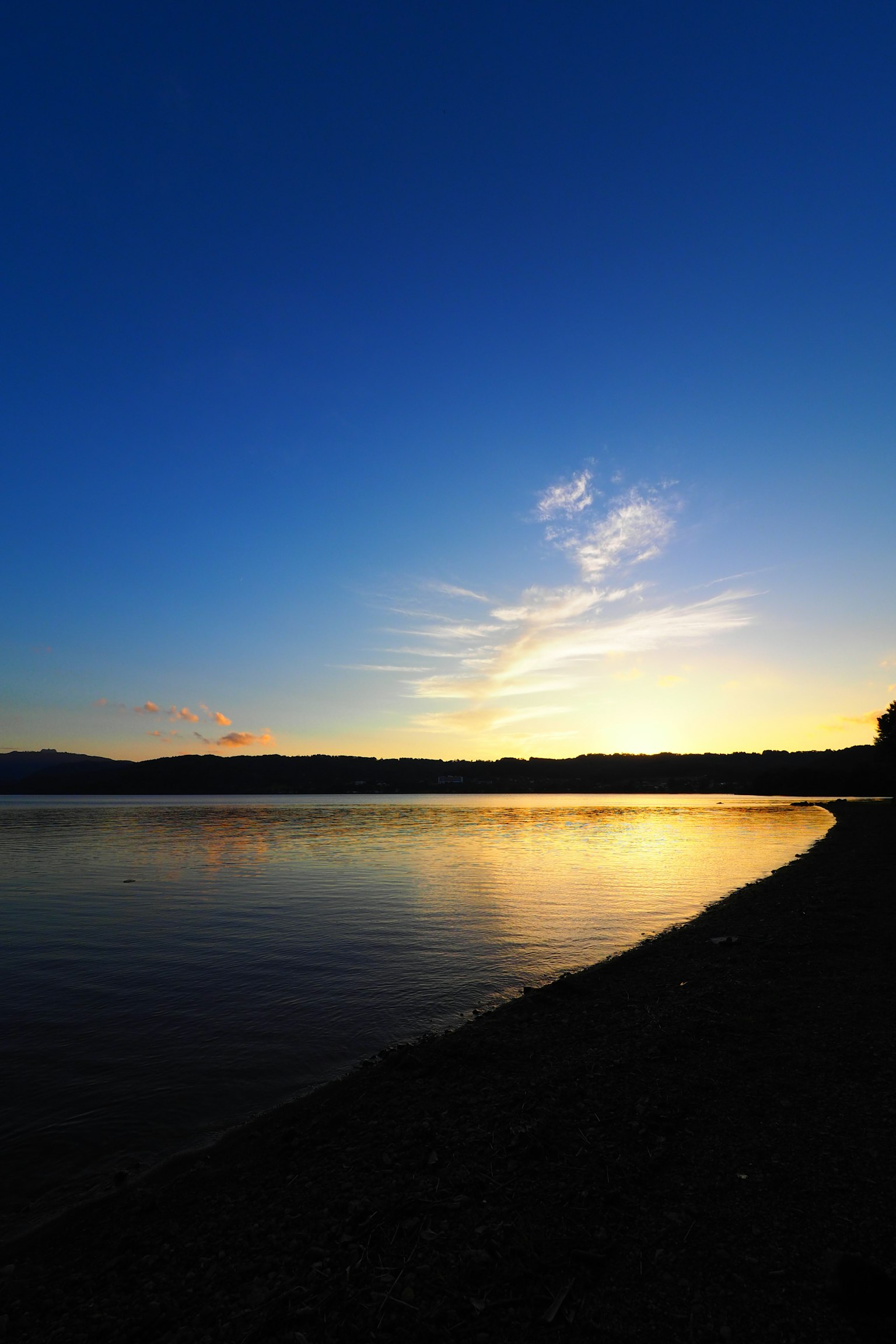 Danau tenang dengan langit matahari terbenam yang indah