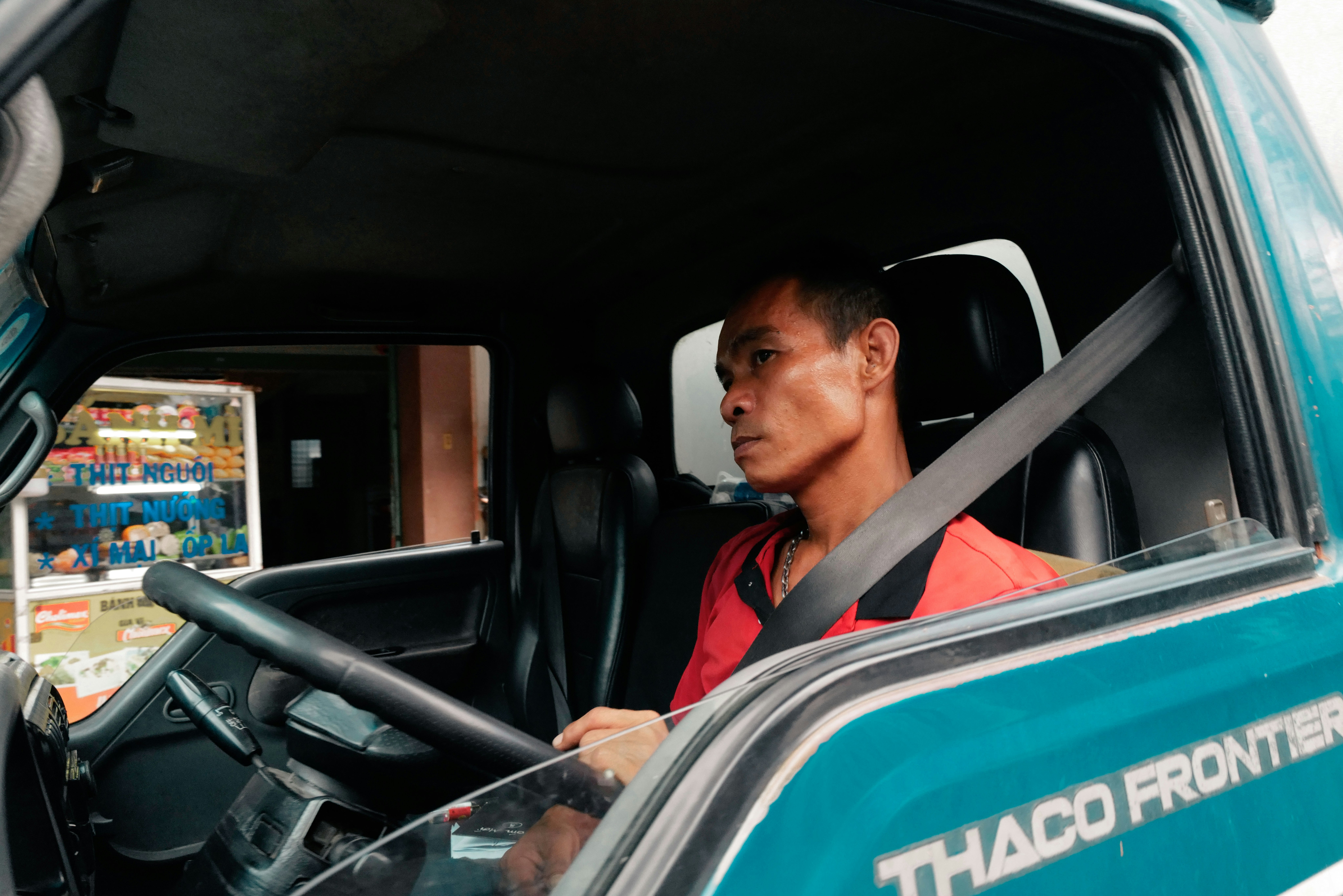 配達用トラックの運転席でハンドルを握る配達員