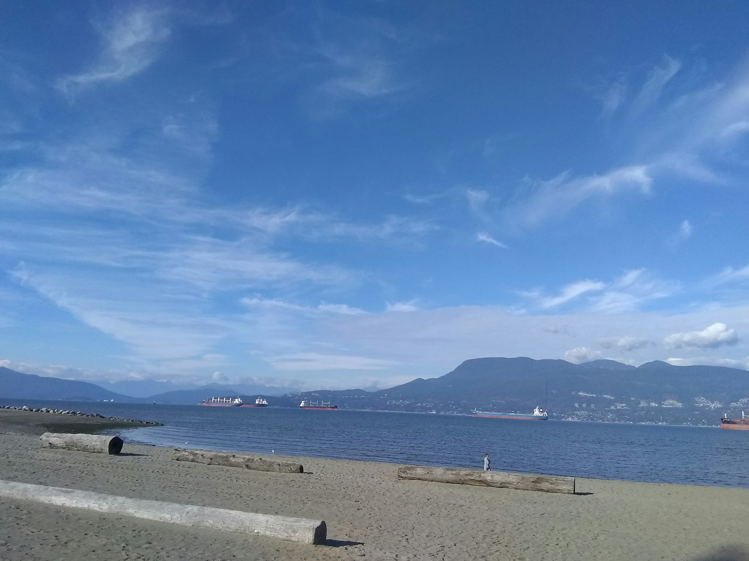 海滩景观，蓝天和远处的山脉