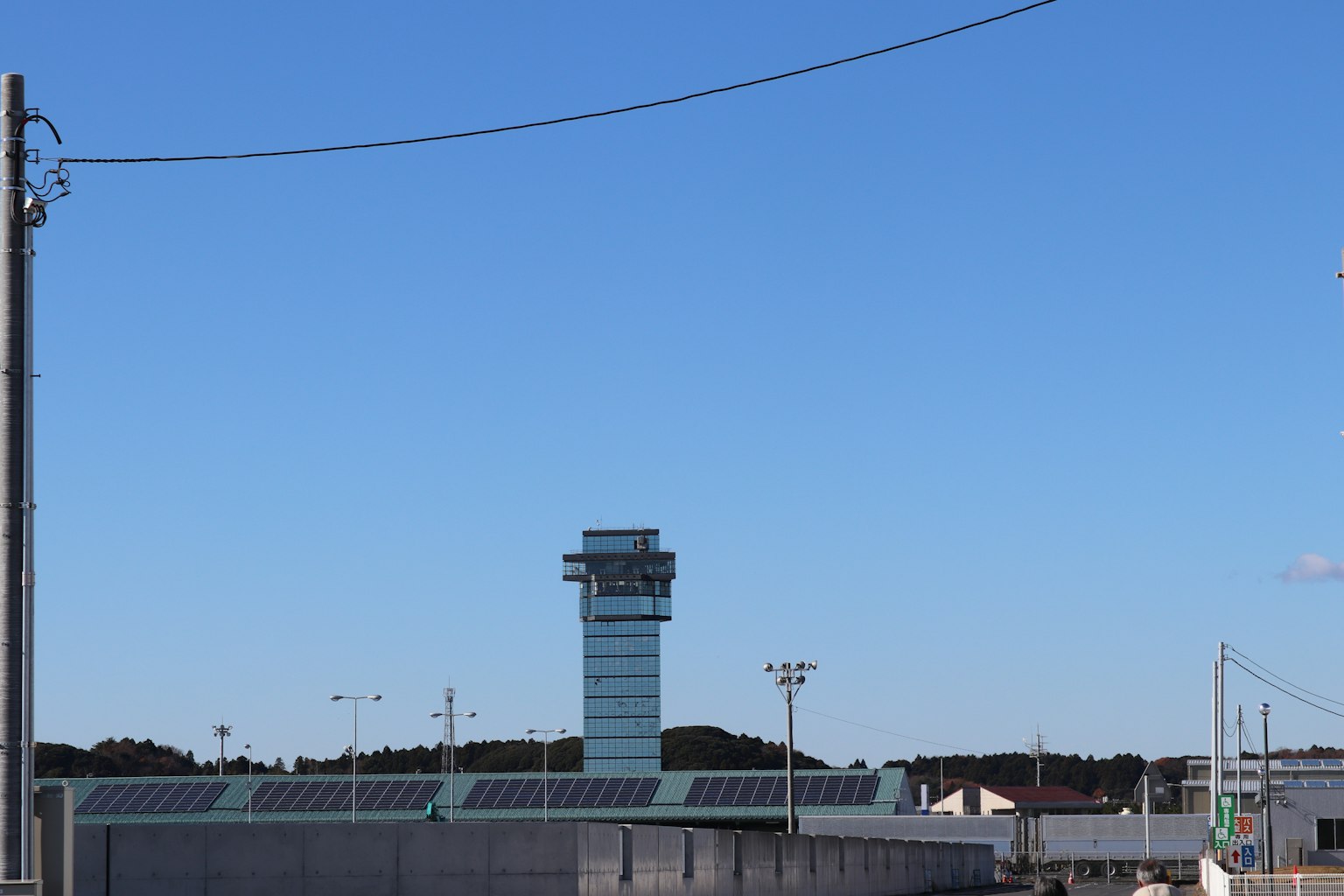 맑은 파란 하늘 아래의 공항 관제탑과 주변 건물들