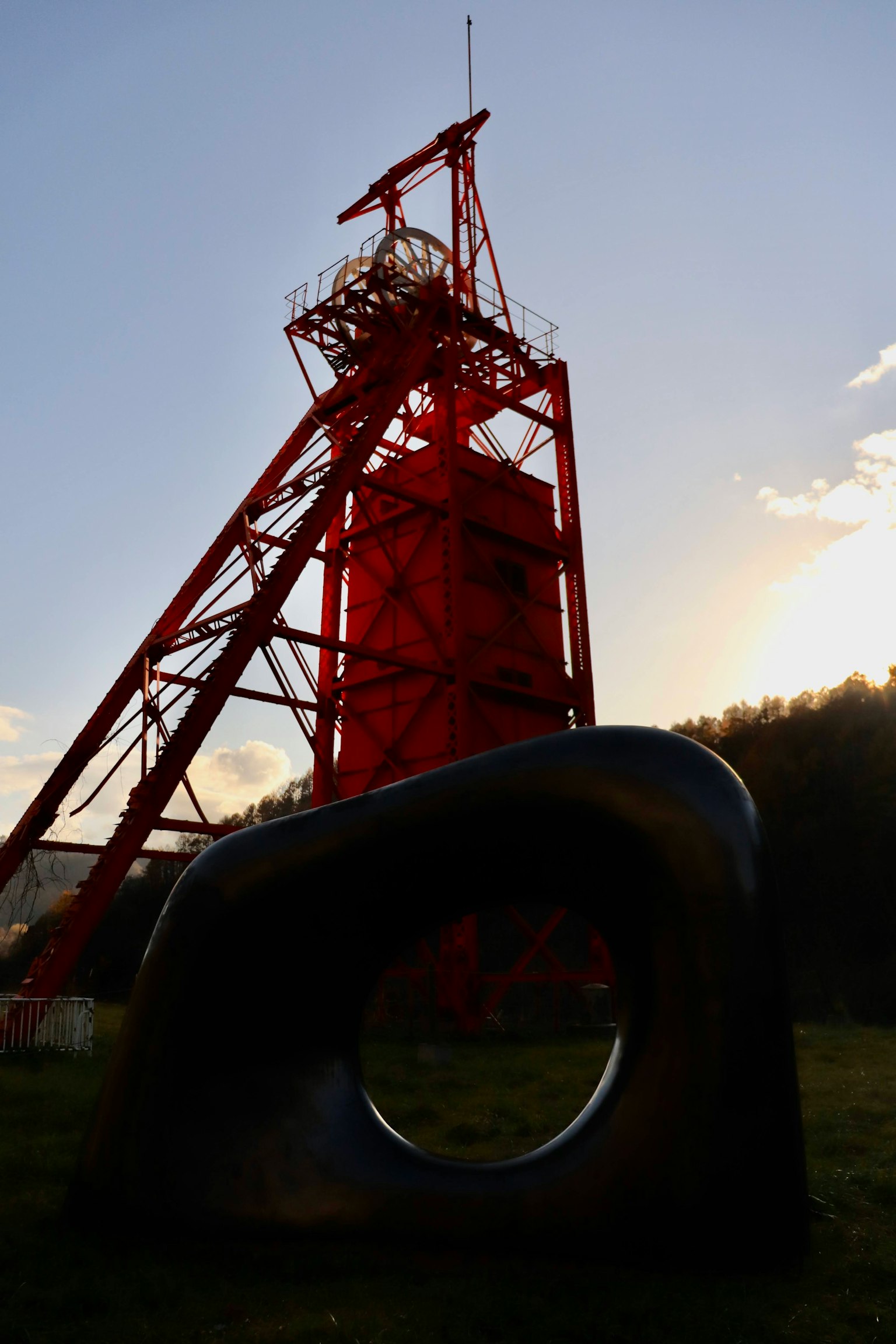 Tour rouge et sculpture noire dans un paysage pittoresque