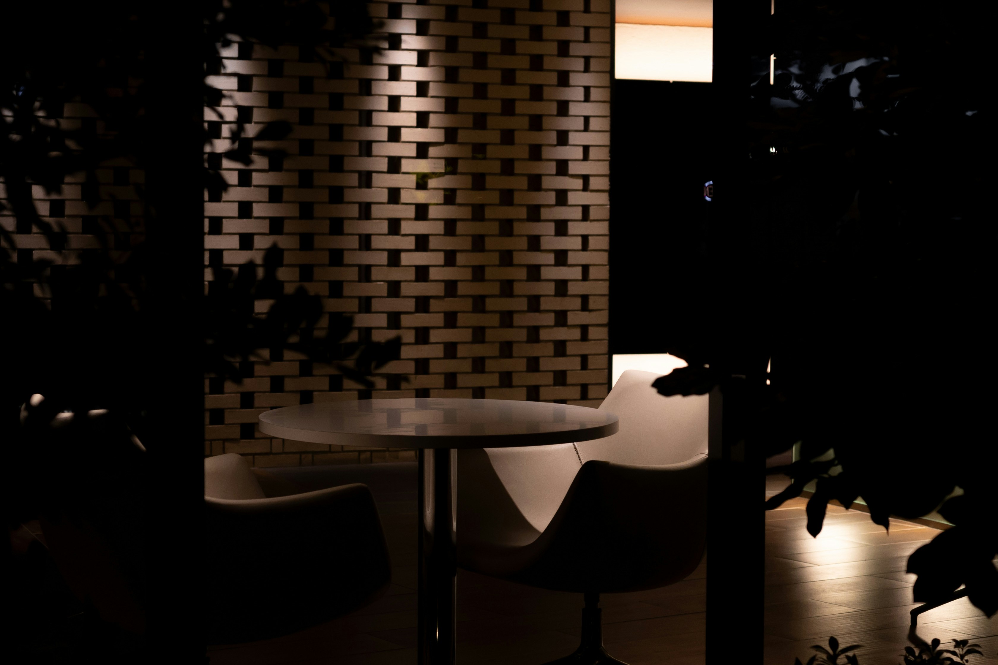indoor seating area with table and chairs beside a brick wall