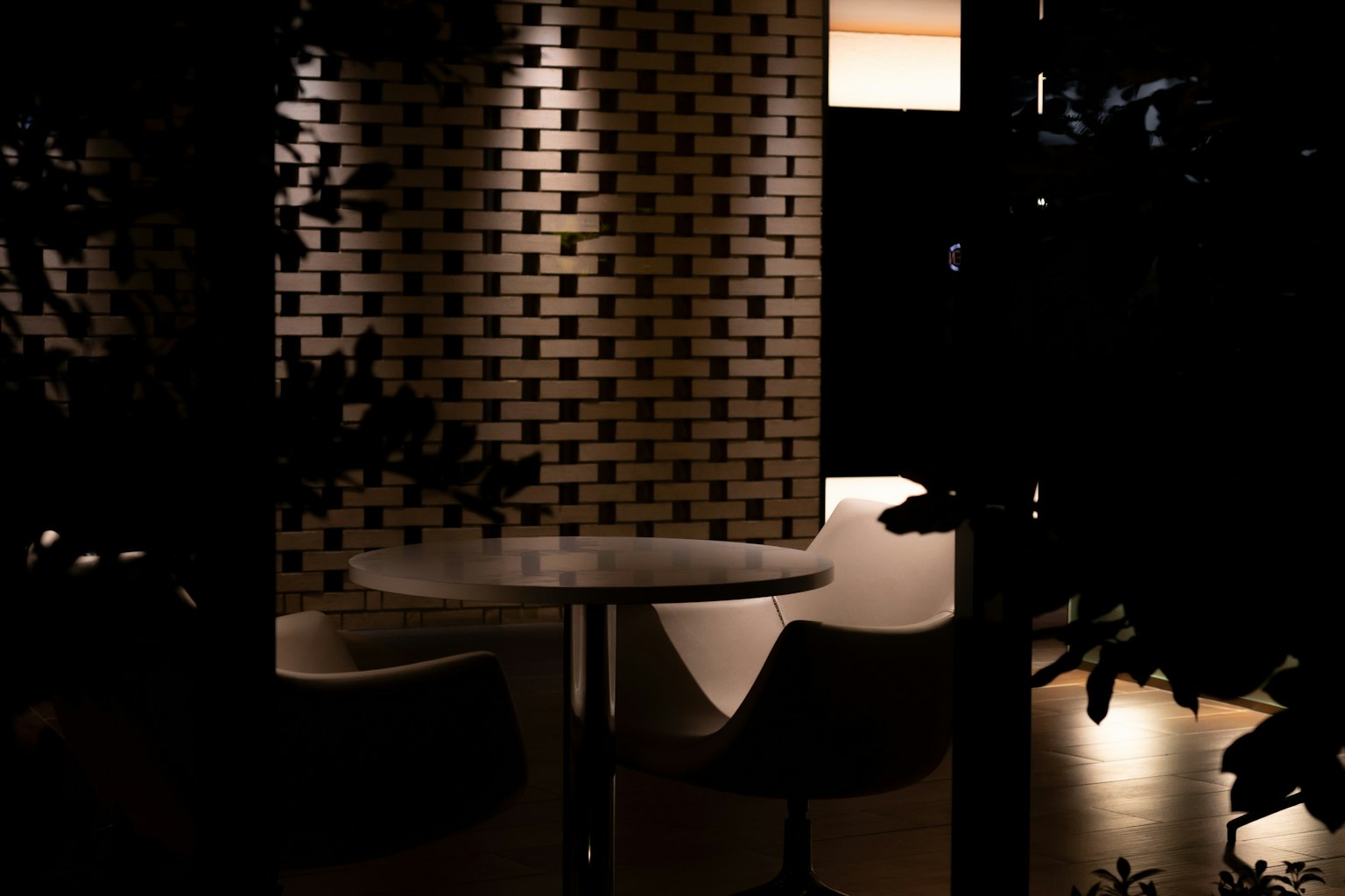 Interno moderno con un tavolo e sedie luminose su uno sfondo scuro