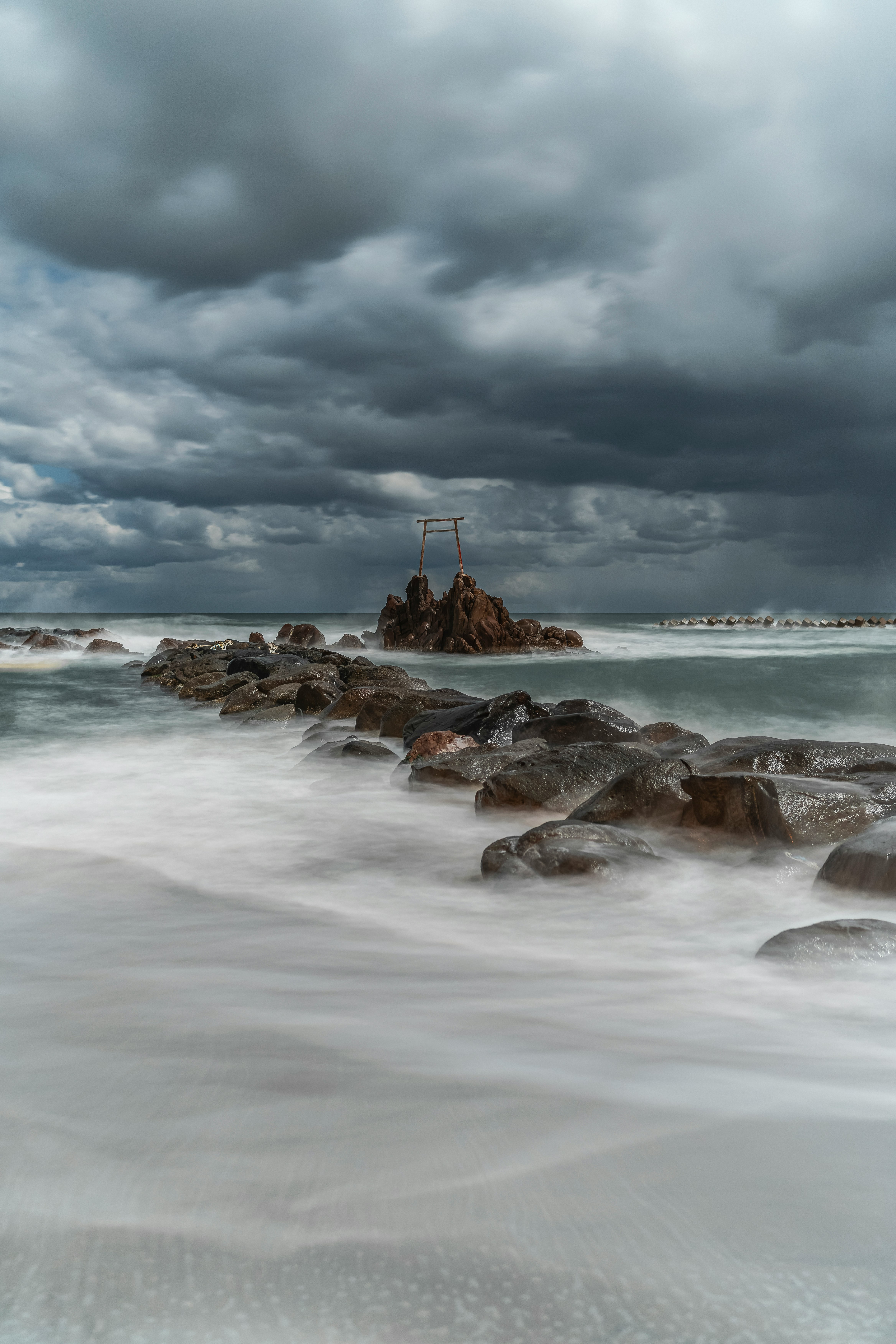 costa rocosa con olas agitadas bajo cielo nublado