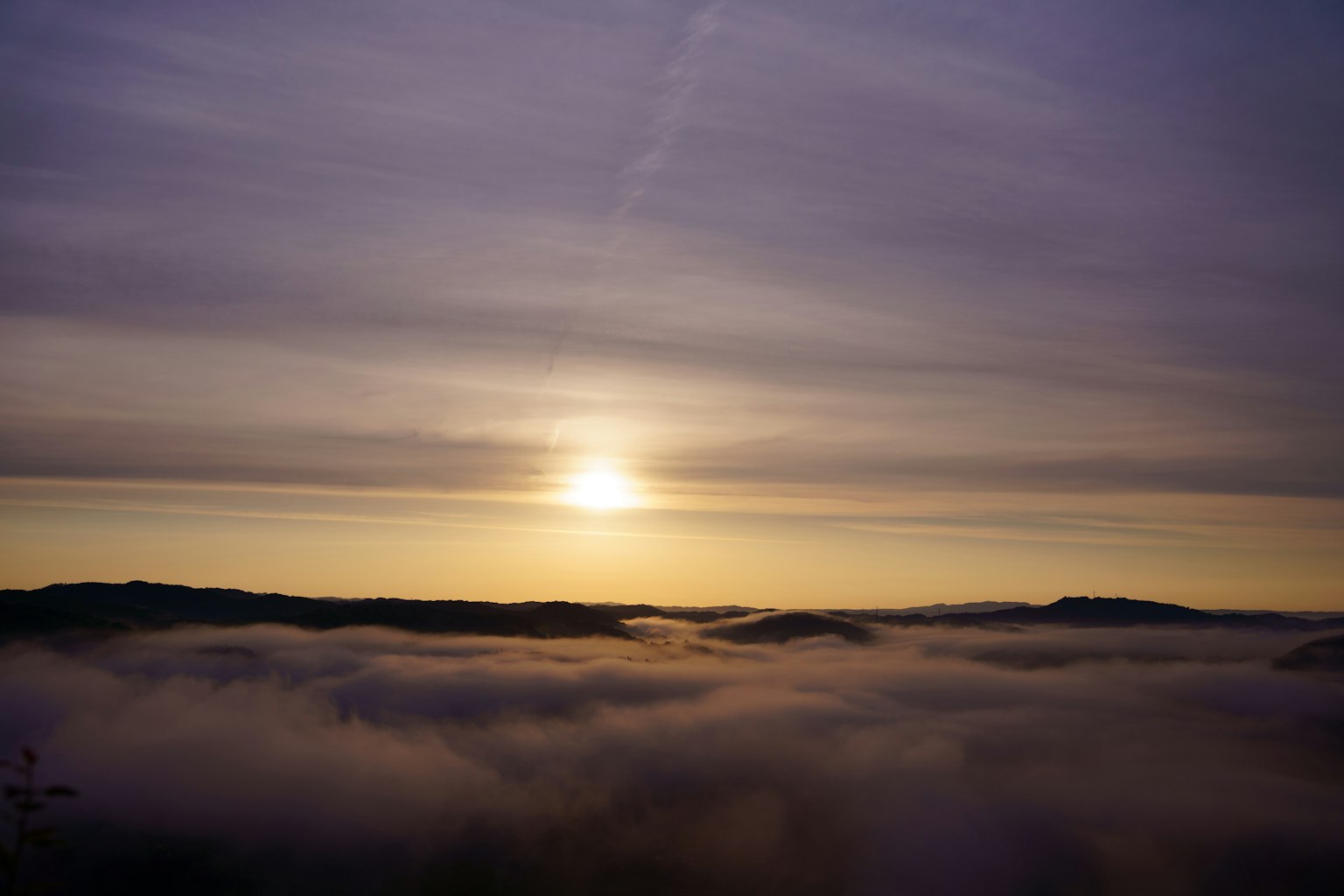 Alba su montagne coperte di nebbia