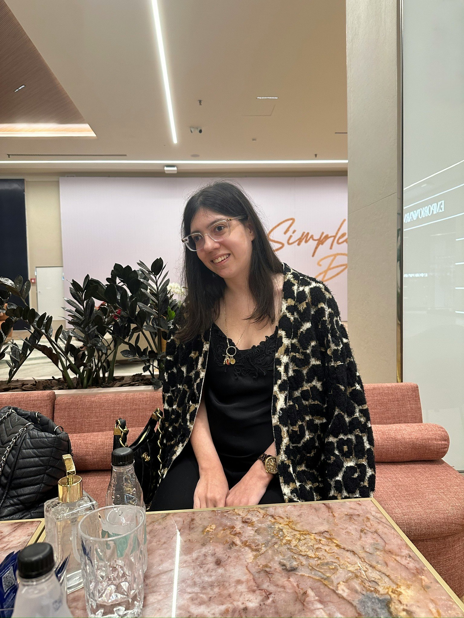 カフェ店内で笑顔の女性とテーブル上の飲み物