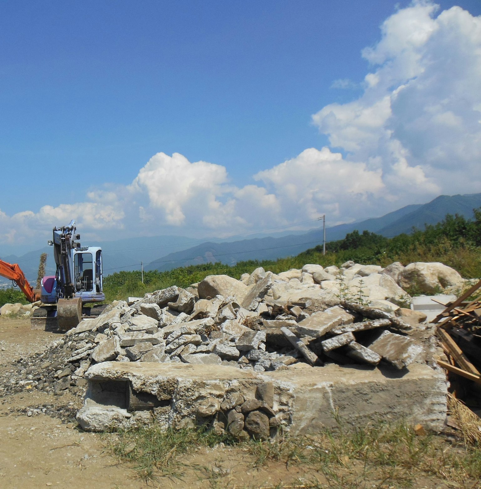 Construction site with rocks and machinery under blue sky