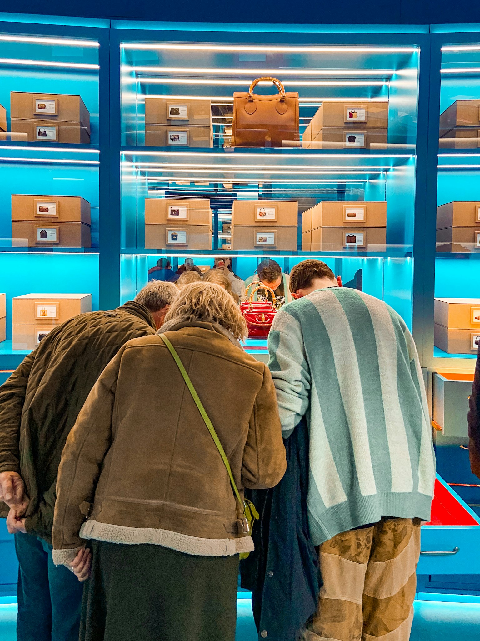 People examining boxes in front of a blue background