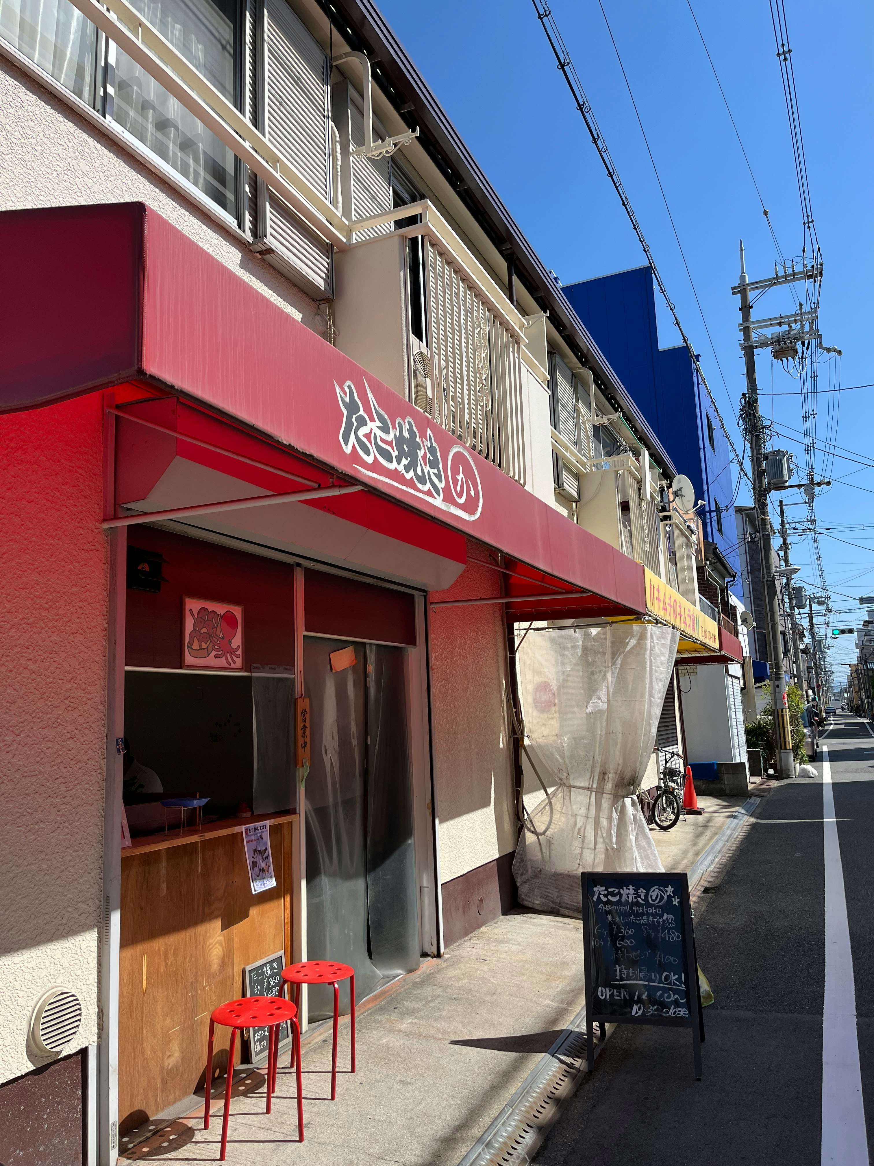 路地の飲食店の軒先と赤い看板