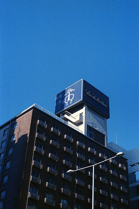 Facciata di hotel con insegne sotto un cielo blu terso