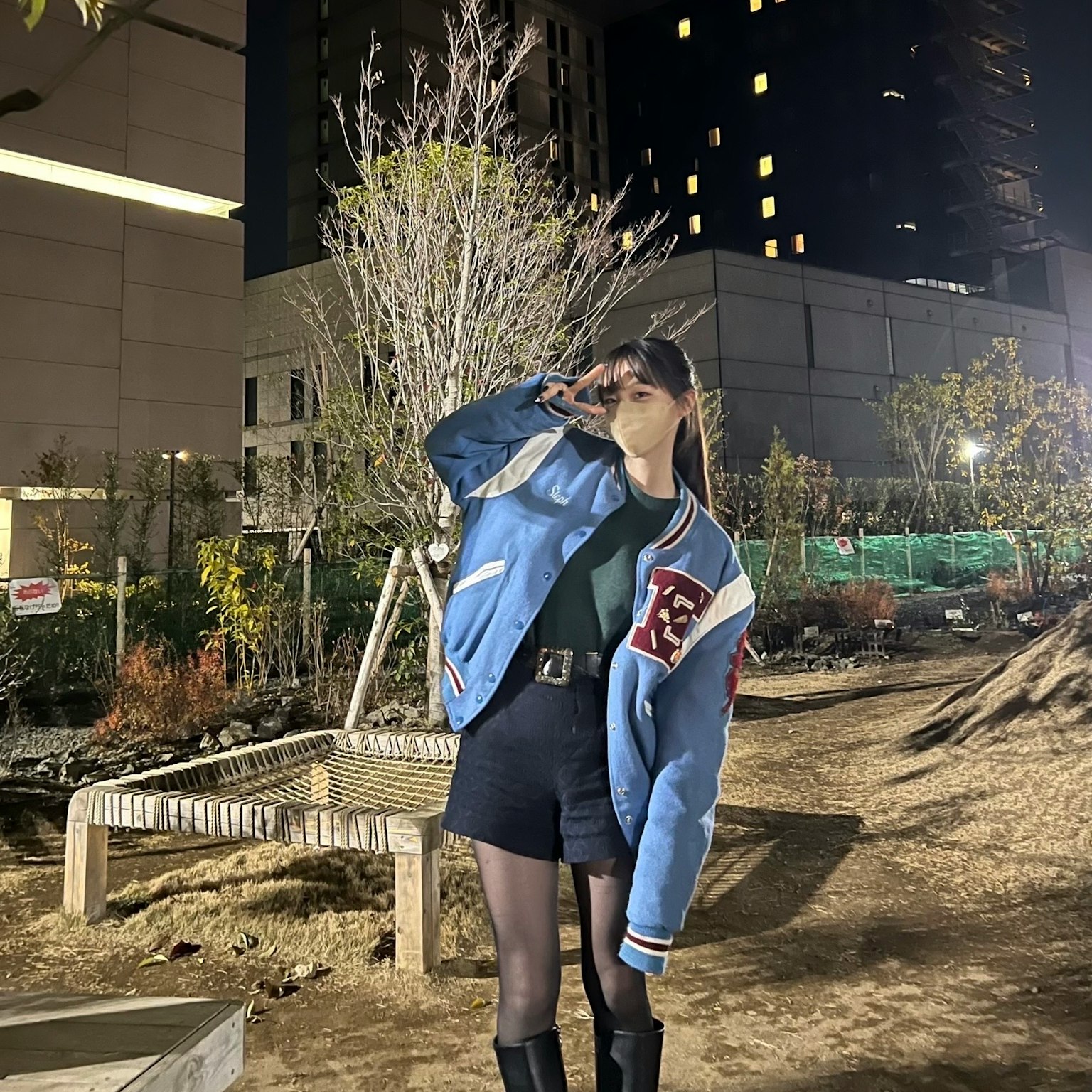 夜間公園中穿著藍色夾克和短褲的女性