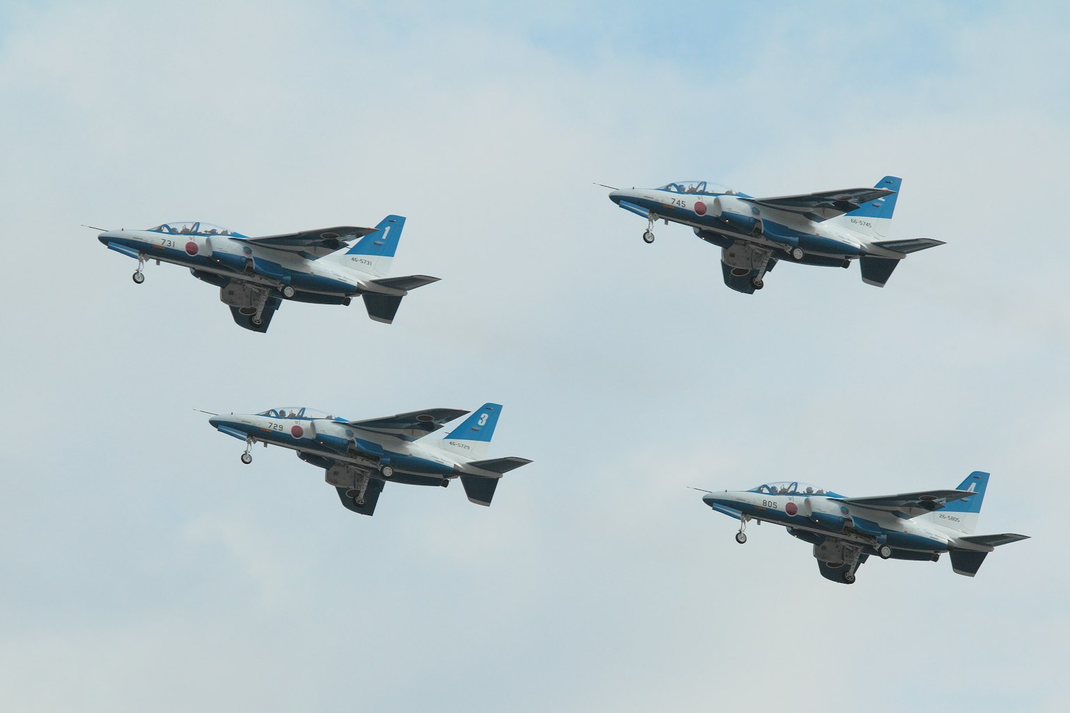 Empat pesawat militer biru dan hitam terbang dalam formasi
