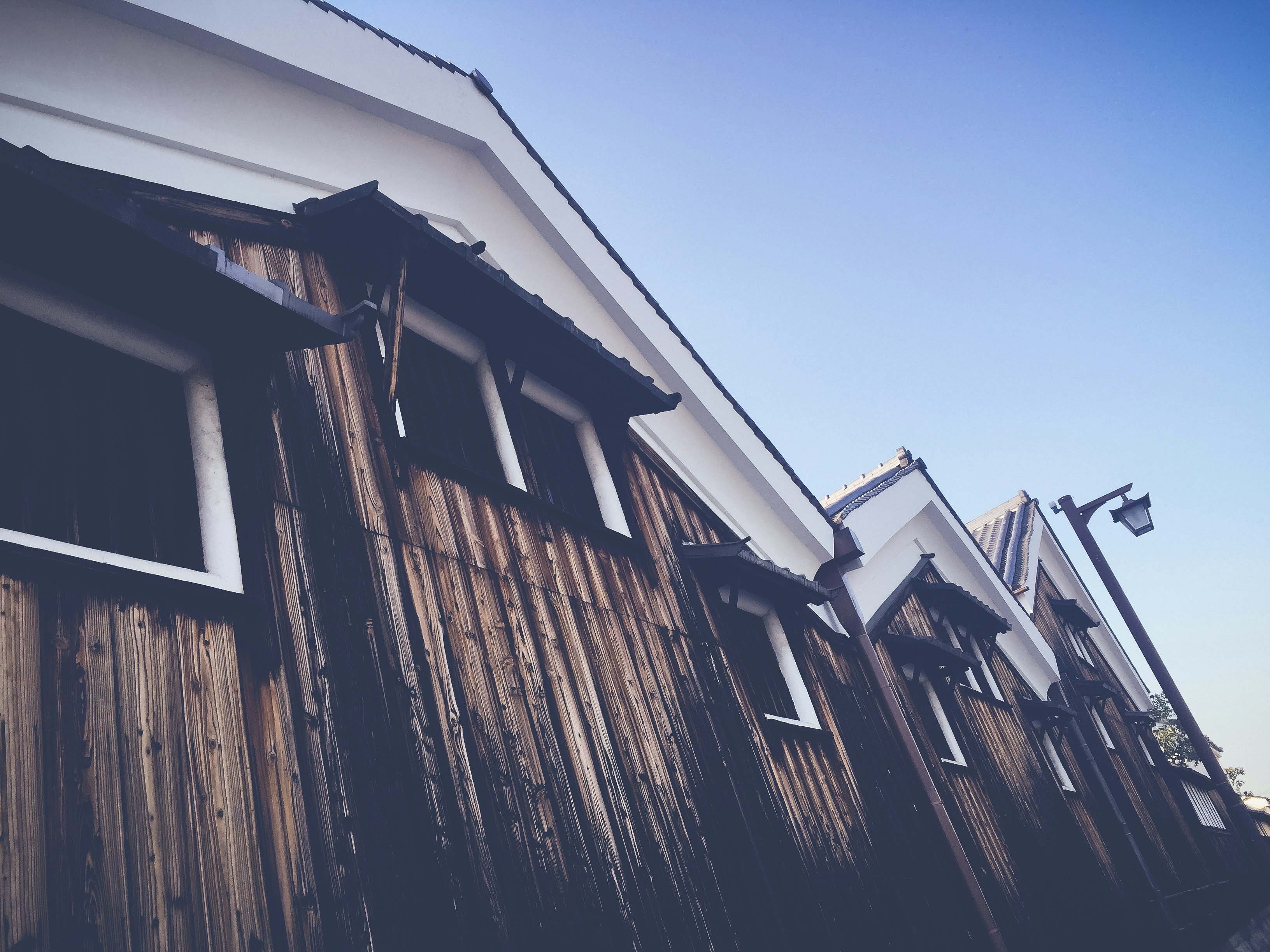 exterior of a narrow lane lined with wooden buildings and eaves