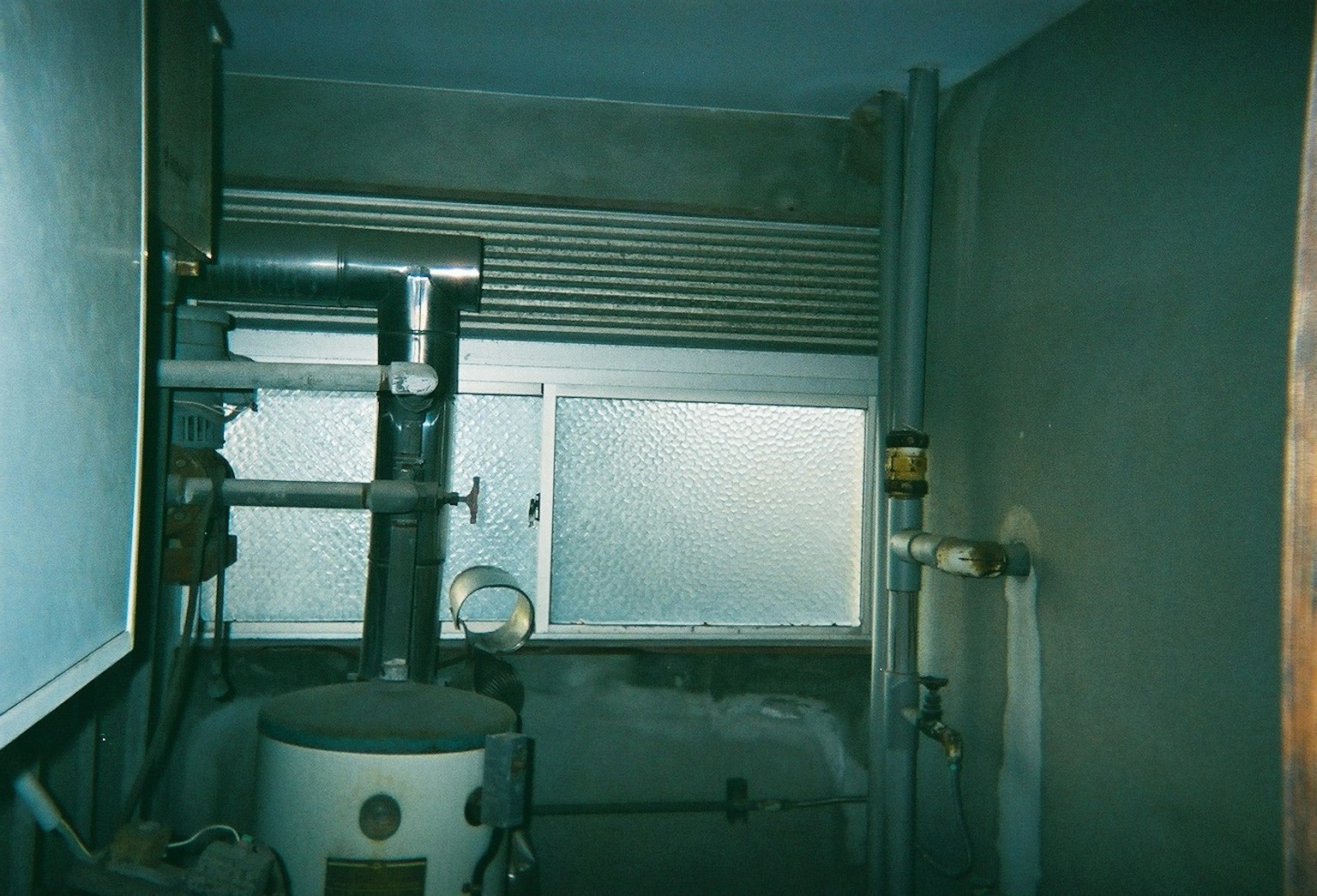 Dimly lit room featuring pipes and a window structure