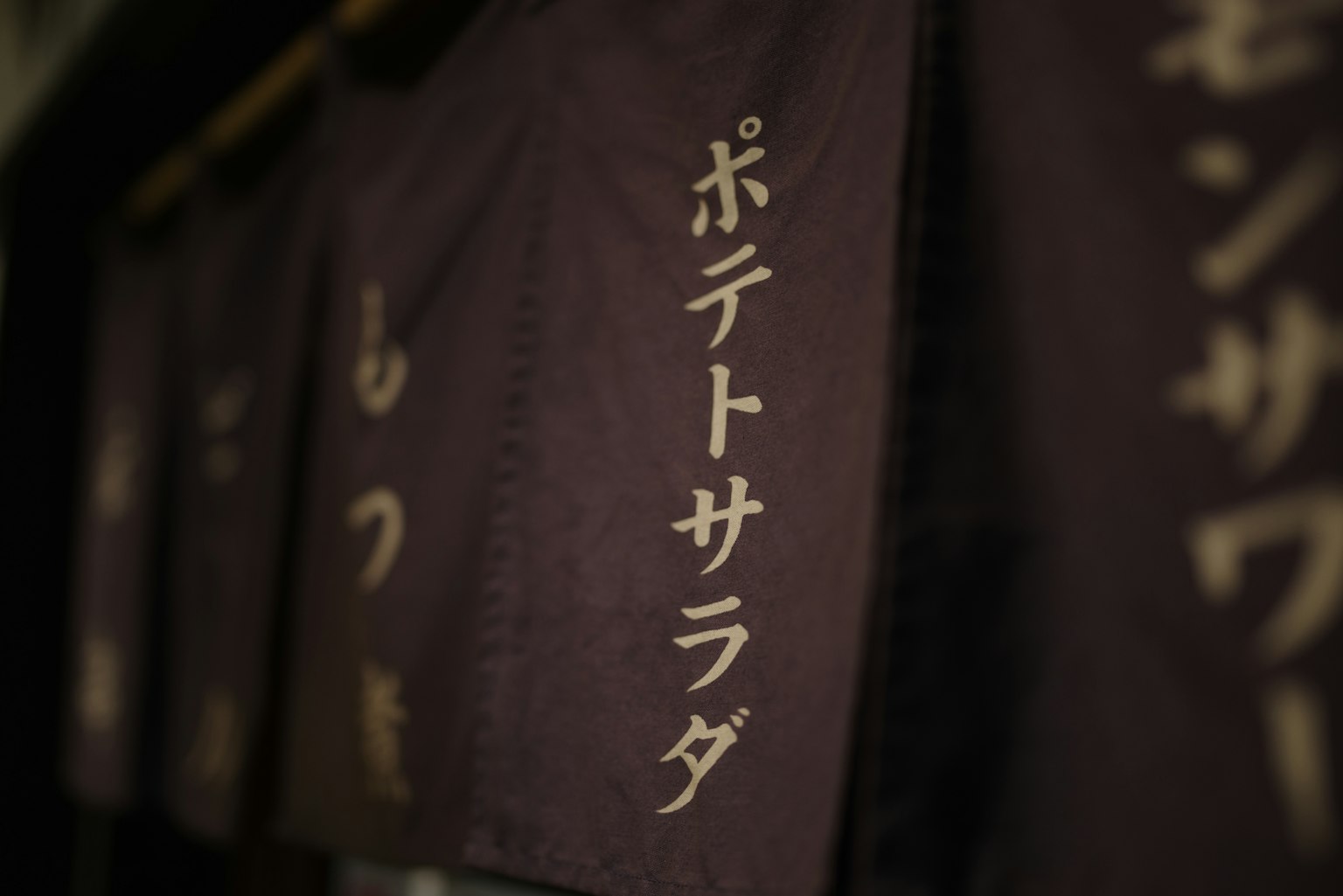 黑色布料上的金色字母书写的日本菜单