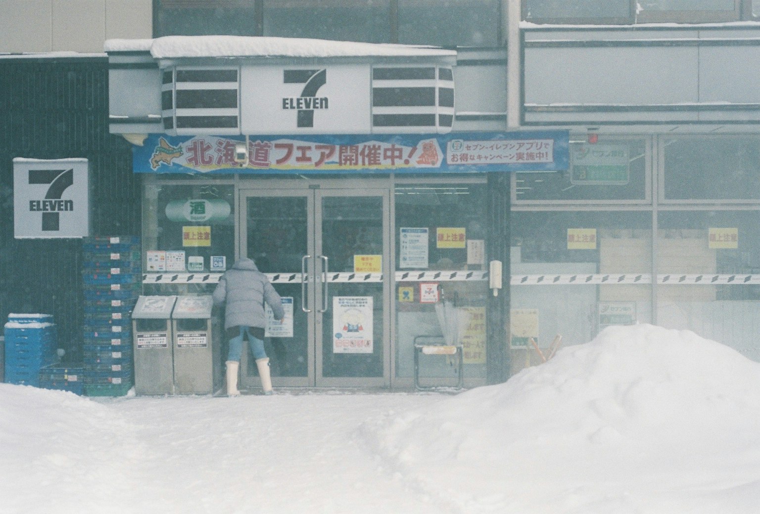 站在被雪覆盖的7-Eleven商店前的人