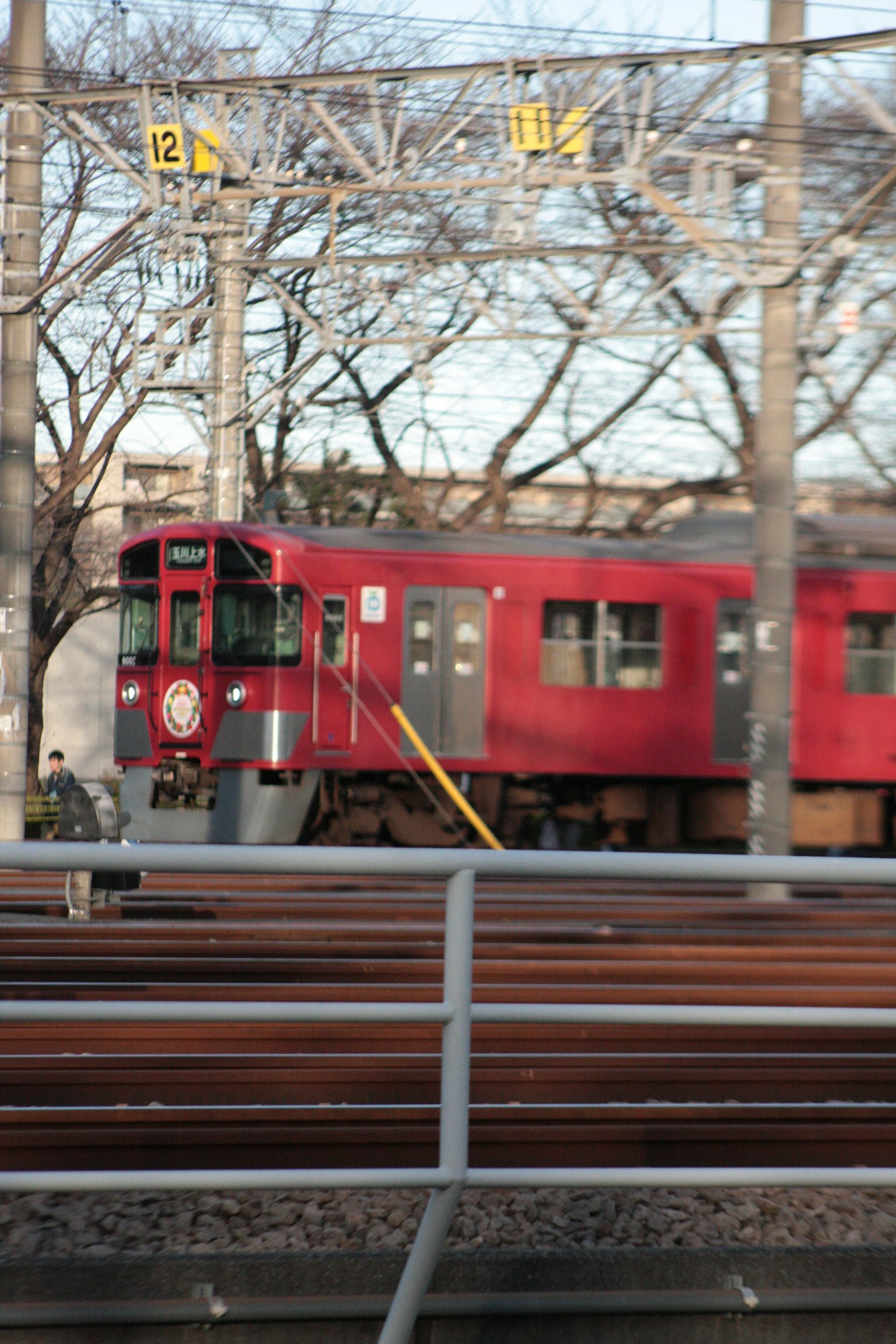 Red train parked on the tracks at a railway station