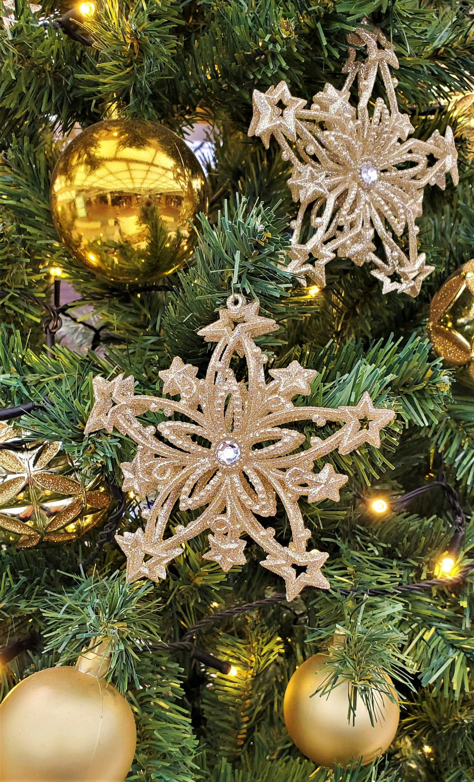 Christmas tree adorned with golden ornaments and snowflake decorations