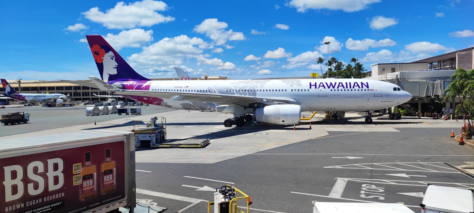Máy bay Hawaiian Airlines đậu tại sân bay dưới bầu trời xanh