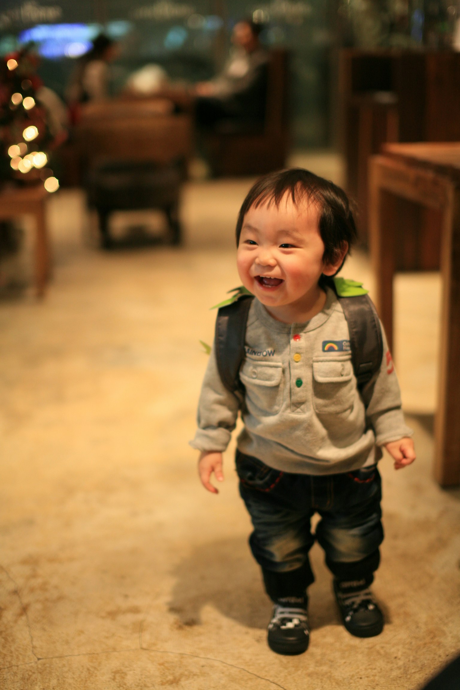 Niño sonriente con una mochila en un ambiente interior acogedor